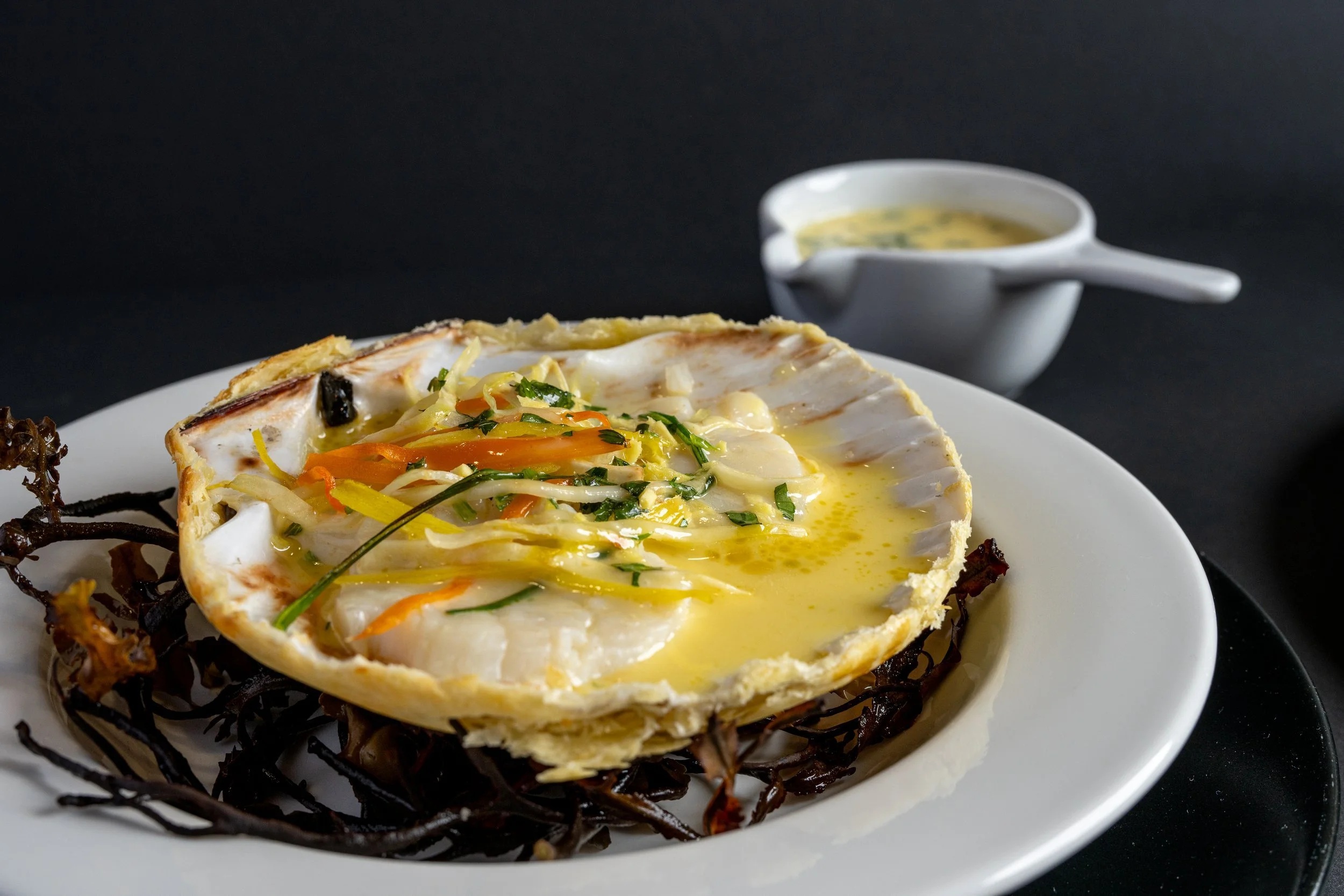 Scottish scallops baked in the shell with a fine vegetable julienne, ginger, coriander, fish stock, Noilly Prat and butter