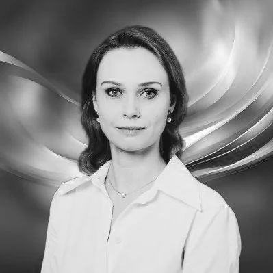 Black and white portrait of a woman with shoulder-length dark hair, wearing a collared shirt, looking directly at the camera.
