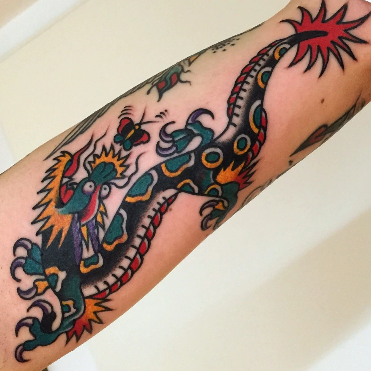 Colorful traditional Japanese-style tattoo of a dragon on a person's arm.