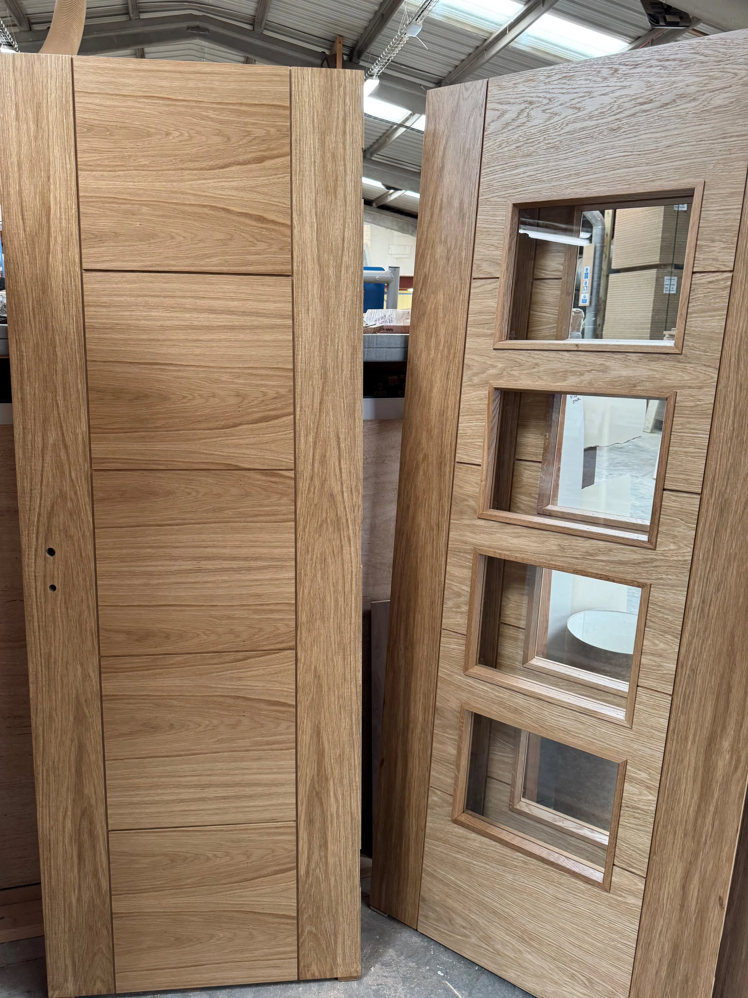 Wooden cabinet and door with glass panels in a woodworking shop.