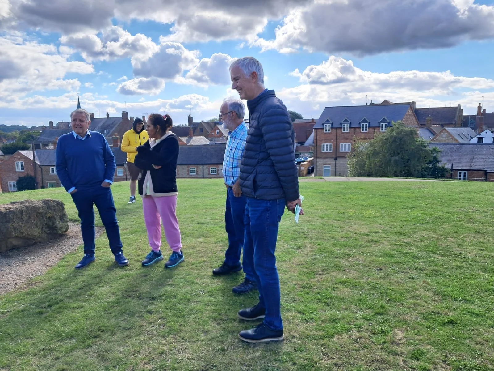 Some church members on top of a grassy hill that is an ancient mound. They are enjoying some free time while on the church day away.