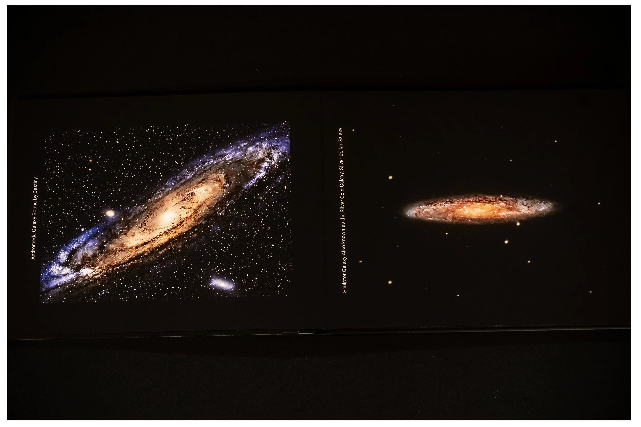 Photograph of two galaxy images on page, one showing the Andromeda Galaxy and the other showing the Sculptor Galaxy, also known as the Silver Dollar Galaxy.