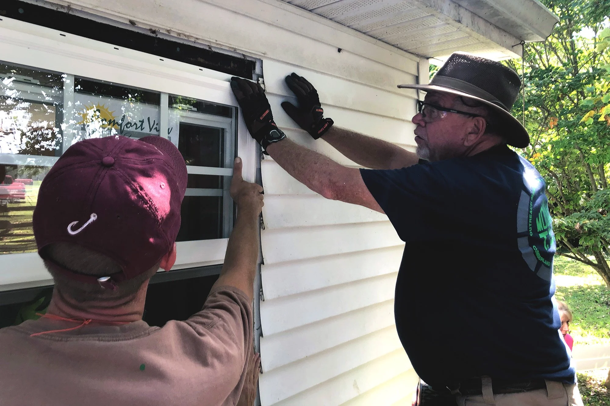 After cutting back the vinyl siding, Mountain T.O.P. volunteers prepare for window replacement — an effort that will cut heating and cooling costs while increasing natural airflow in the spring and autumn months.
