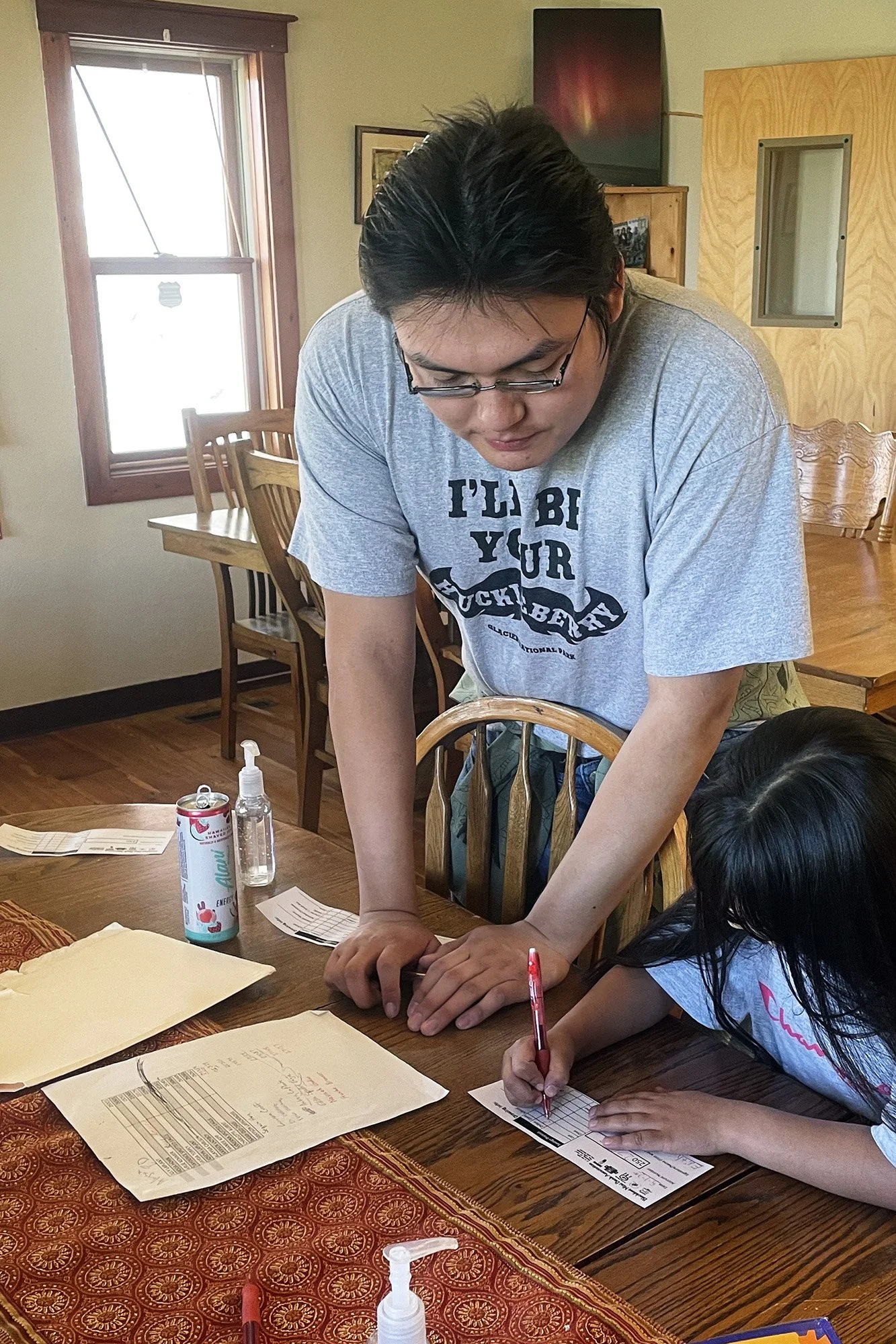 Today, Shannon Bear Medicine teaches a Mini-Bank program participant how to complete a bank deposit form.
