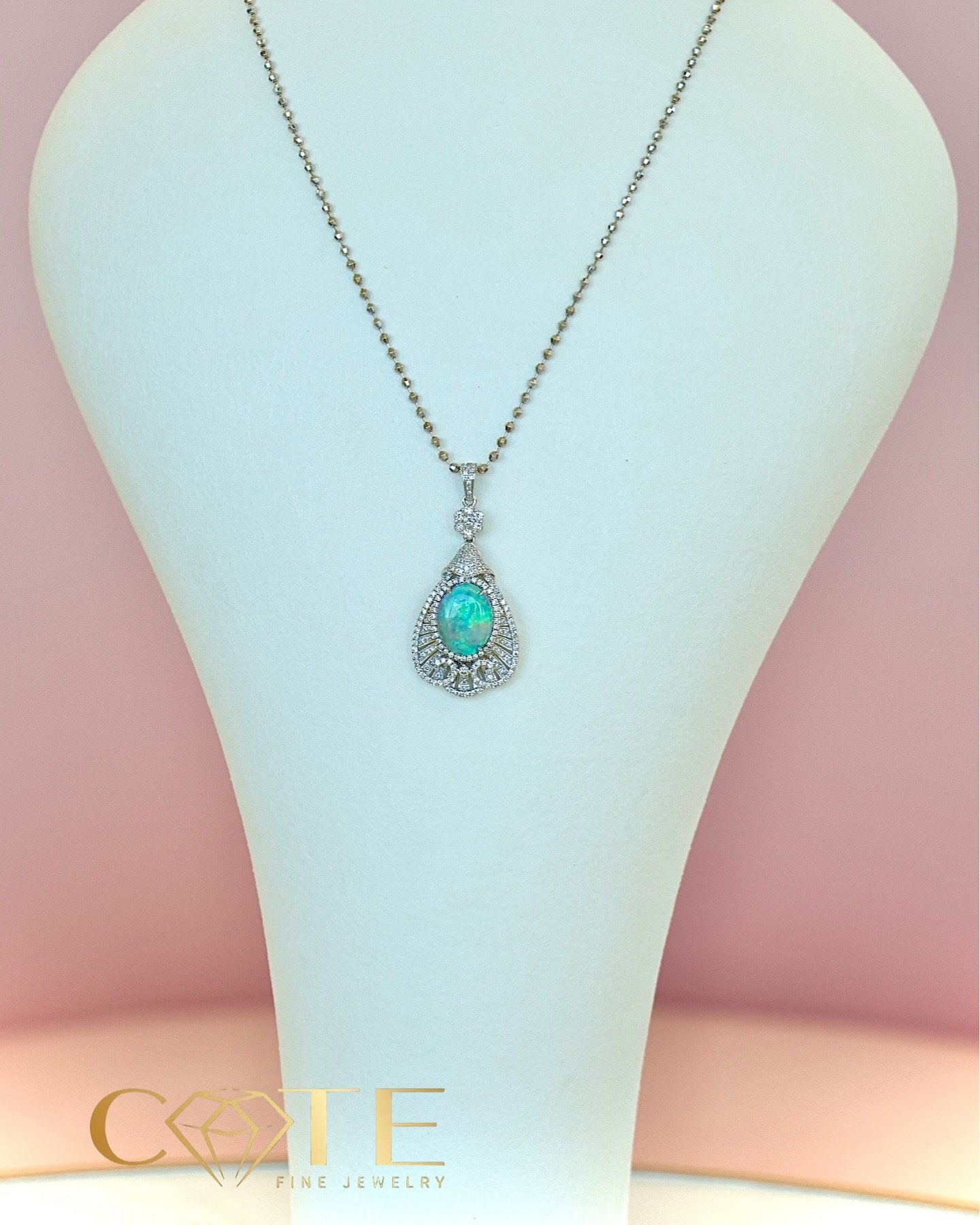 This exquisite opal necklace is a true celebration of elegance and mystery. Set in 18K white gold, the pendant takes the form of a delicate diamond-shaped frame, perfectly cradling a luminous opal at its heart. The opal shimmers with an ever-changing