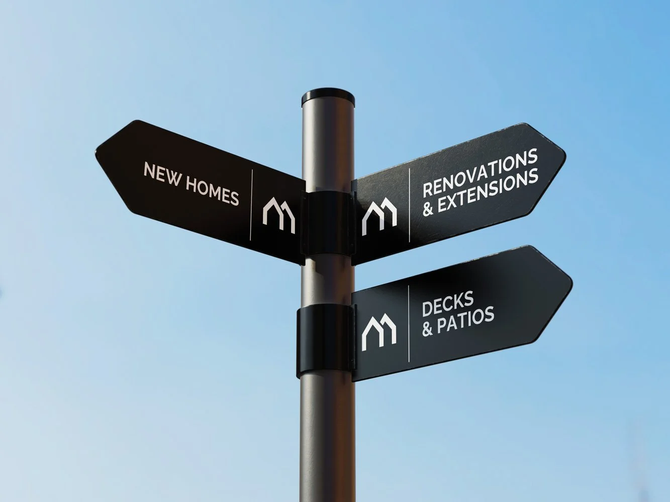 Signpost with directions to new homes, renovations and extensions, decks, and patios, set against a clear blue sky.
