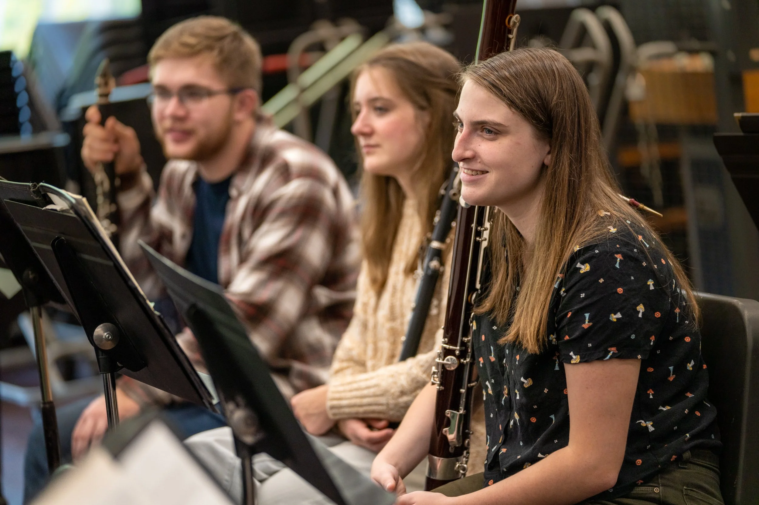 Collegiate orchestral musicians listening to David in rehearsal