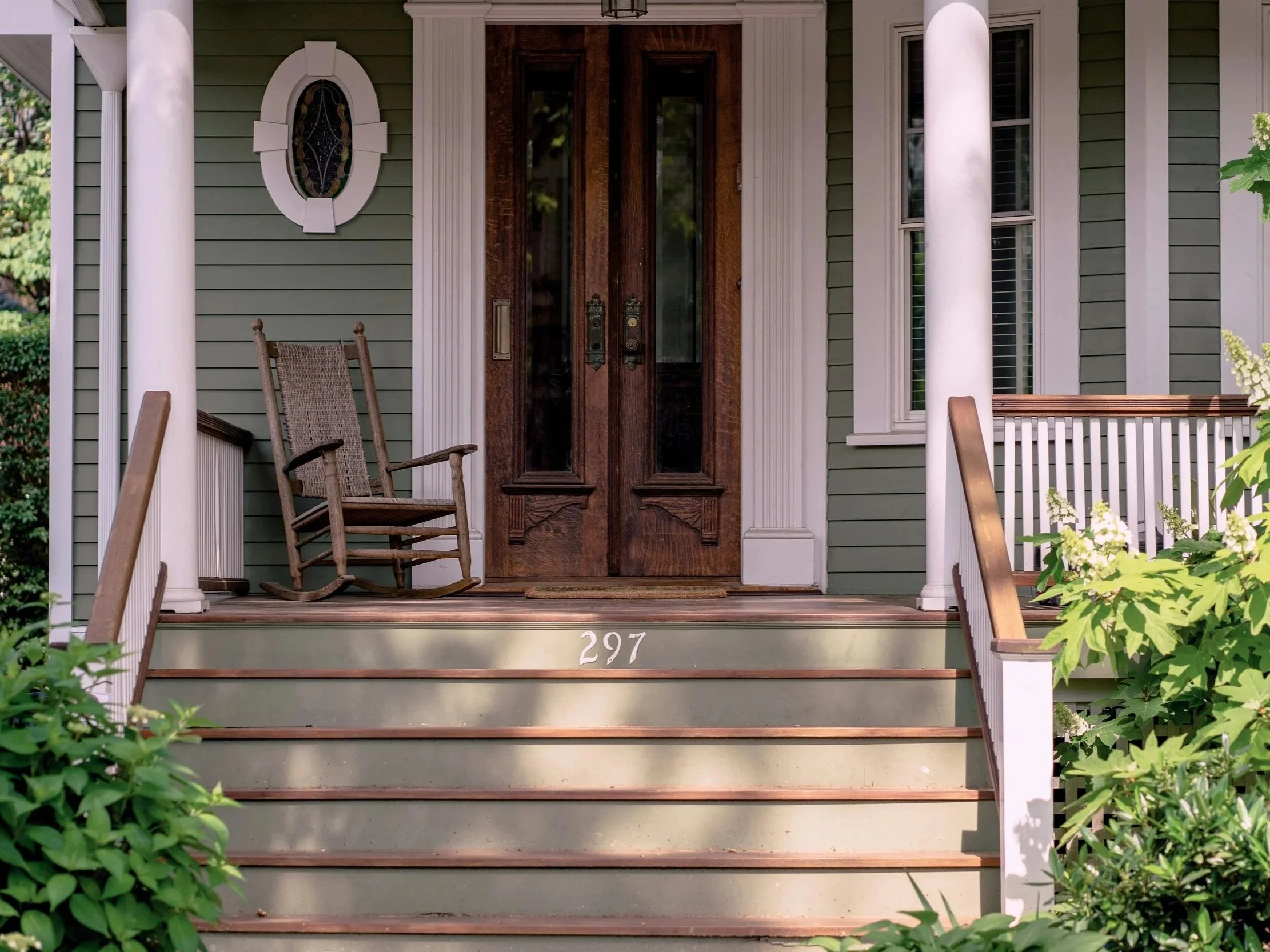 Front porch renovation featuring mahogany stairs, mahogany deck, painted railings, columns, and clapboard siding on a Lake George, NY home.
