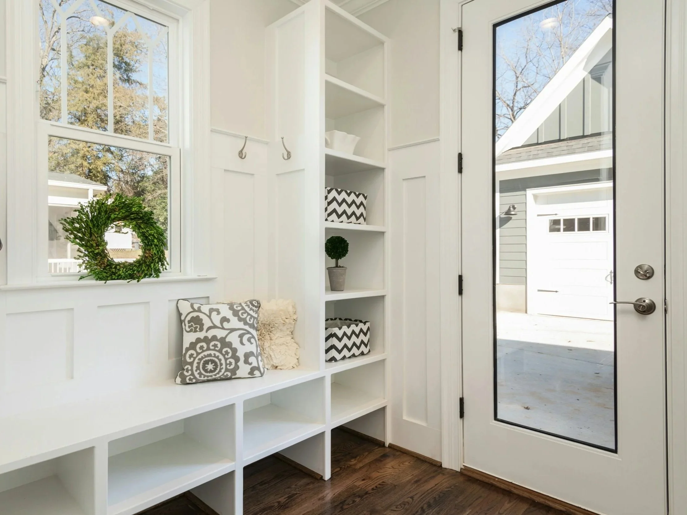 Mudroom addition with a custom bench, storage, and wall paneling in Queensbury, NY.
