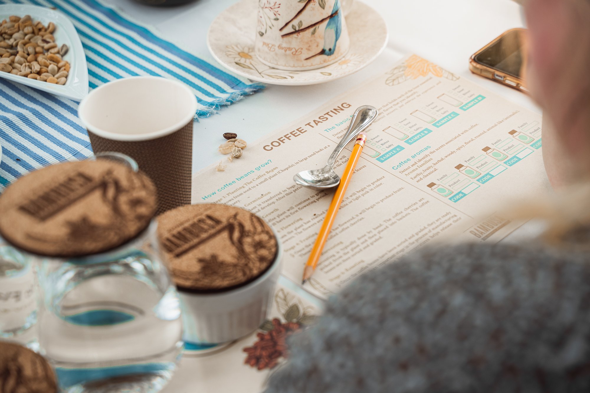 Coffee tasting flight with cups, tasting notes and beans laid out on a table at a small family farm in the Eje Cafetero, Colombia
