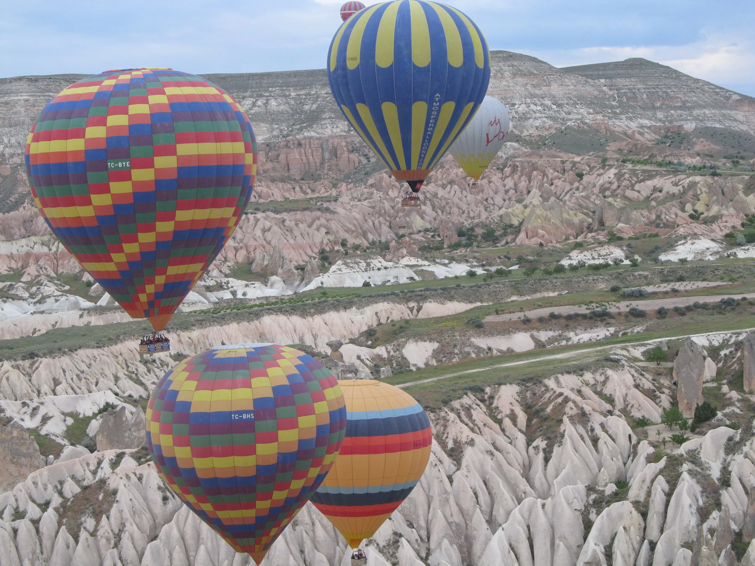 Hot air balloons floating over the fairy chimney rock formations of Cappadocia at sunrise, Turkey