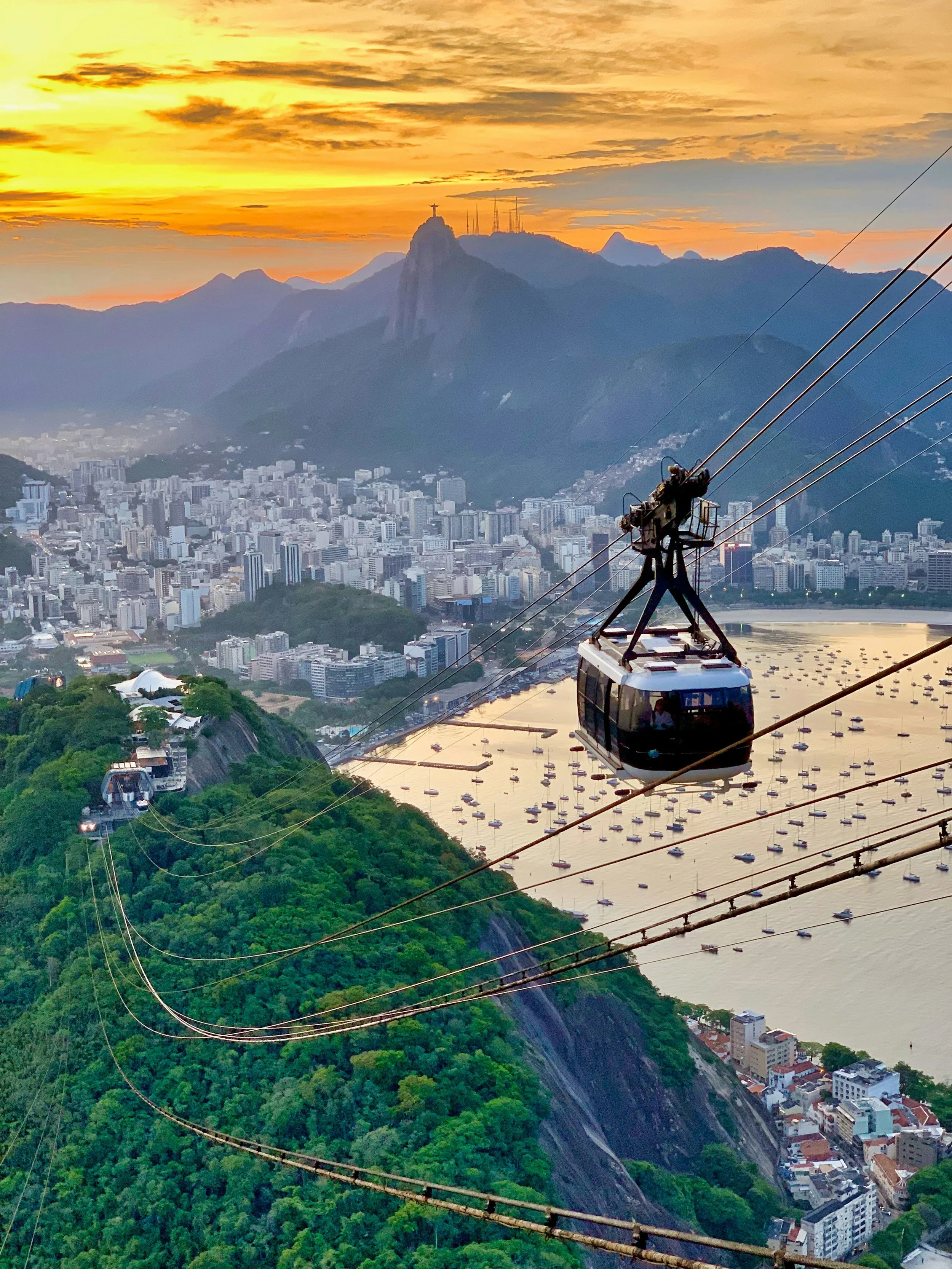 Cable car ascending Sugarloaf Mountain at dawn with Rio de Janeiro's beaches and skyline spread out below, Brazil