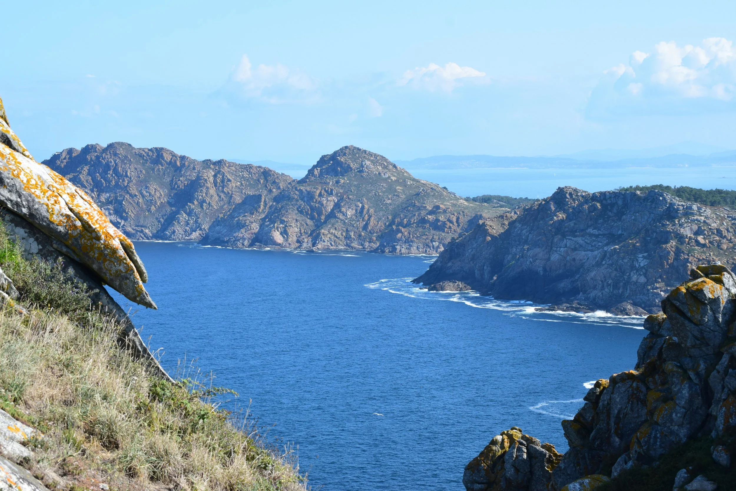 Wild rocky Atlantic coastline of Galicia with lichen-covered granite boulders, rugged headlands and deep blue sea stretching to the horizon, northwestern Spain
