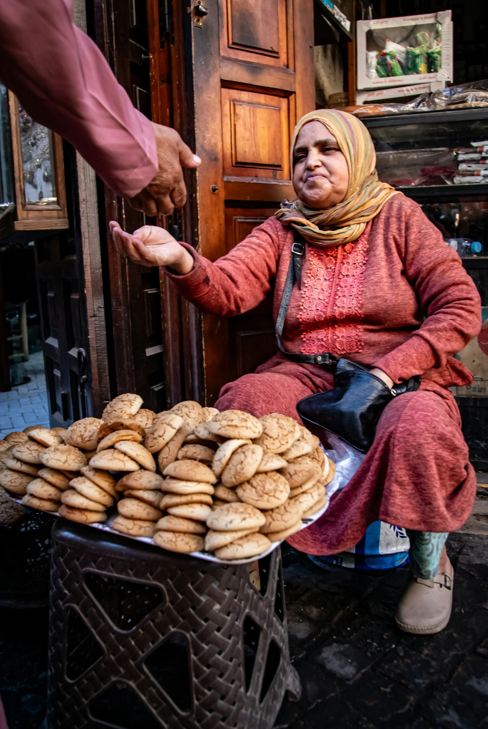 Local Moroccan woman selling traditional bread at a medina market stall on a private food tour