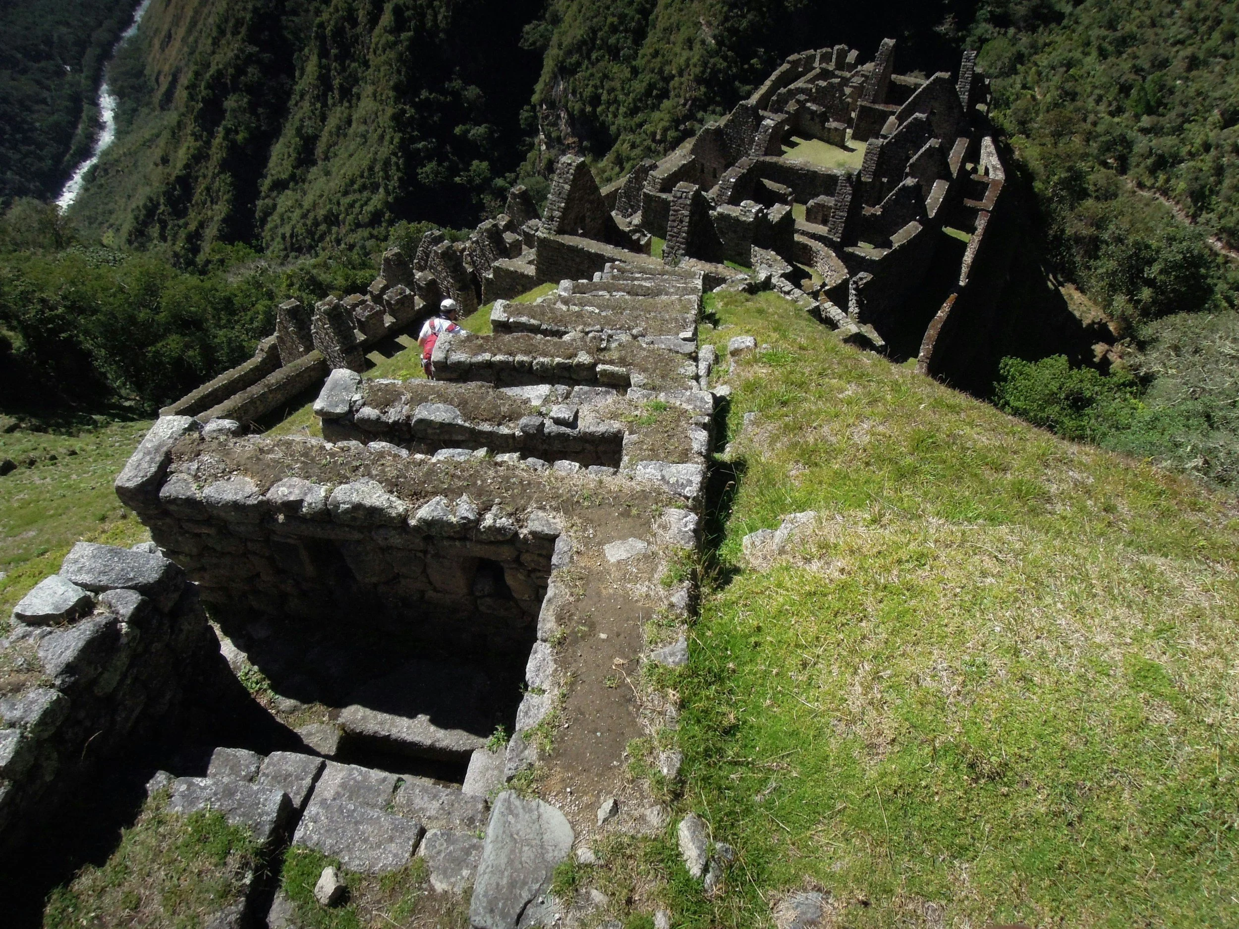 Hiker arriving through the Inti Punku Sun Gate with Machu Picchu visible below, Peru