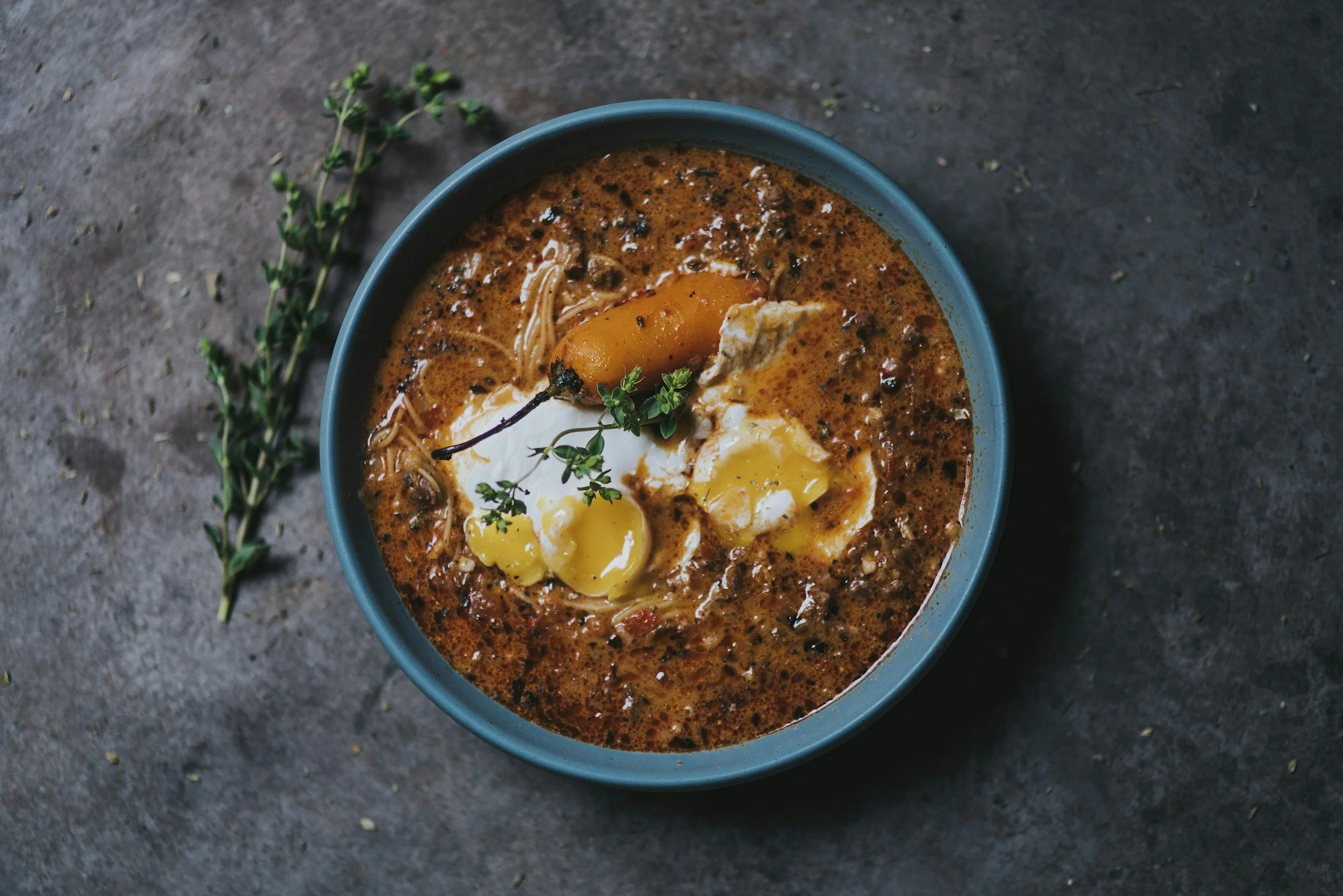Bowl of traditional Peruvian soup garnished with fresh herbs and egg, served on a private culinary journey through Peru