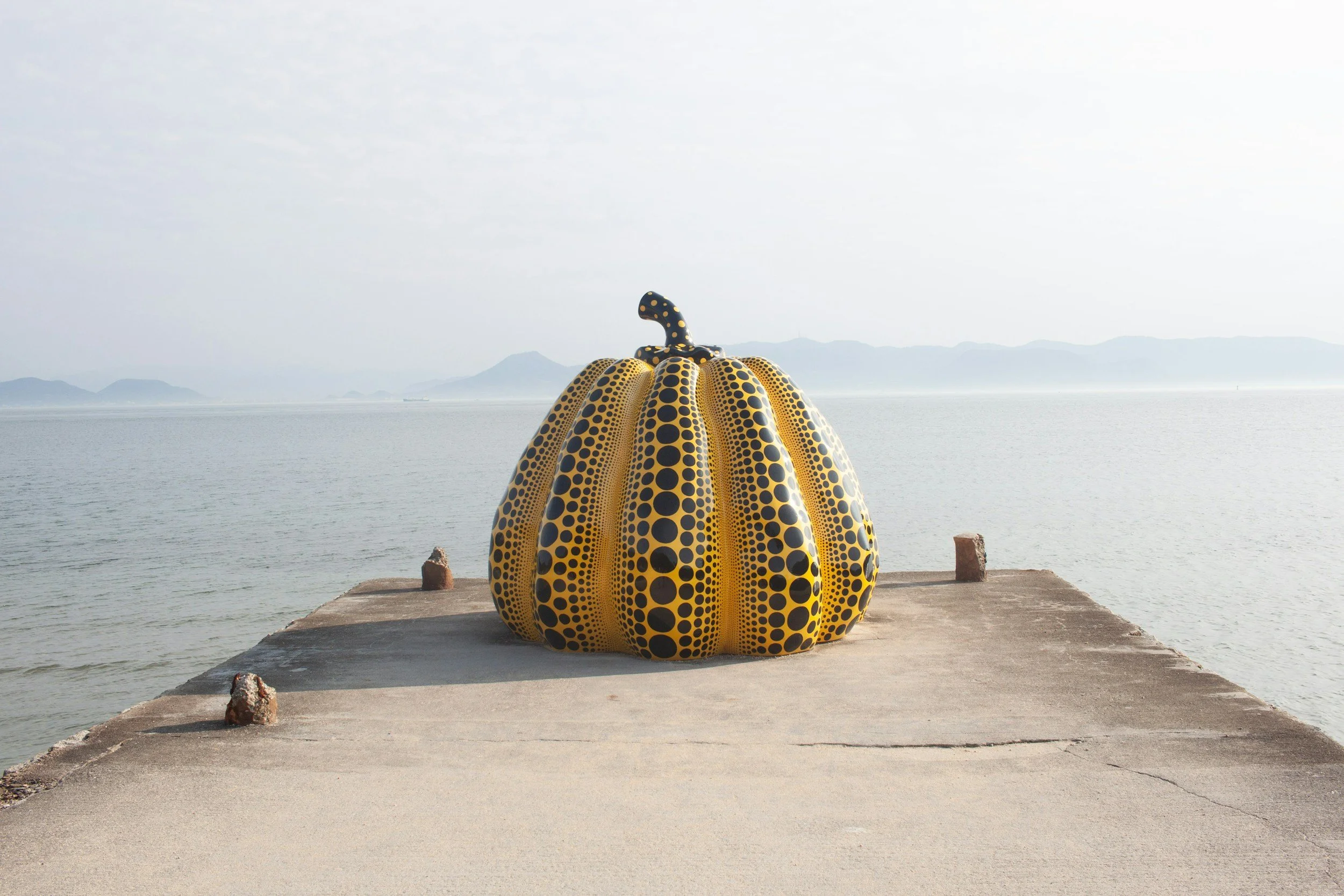 Yayoi Kusama's iconic yellow pumpkin sculpture on the pier of Naoshima art island in the Seto Inland Sea, Japan
