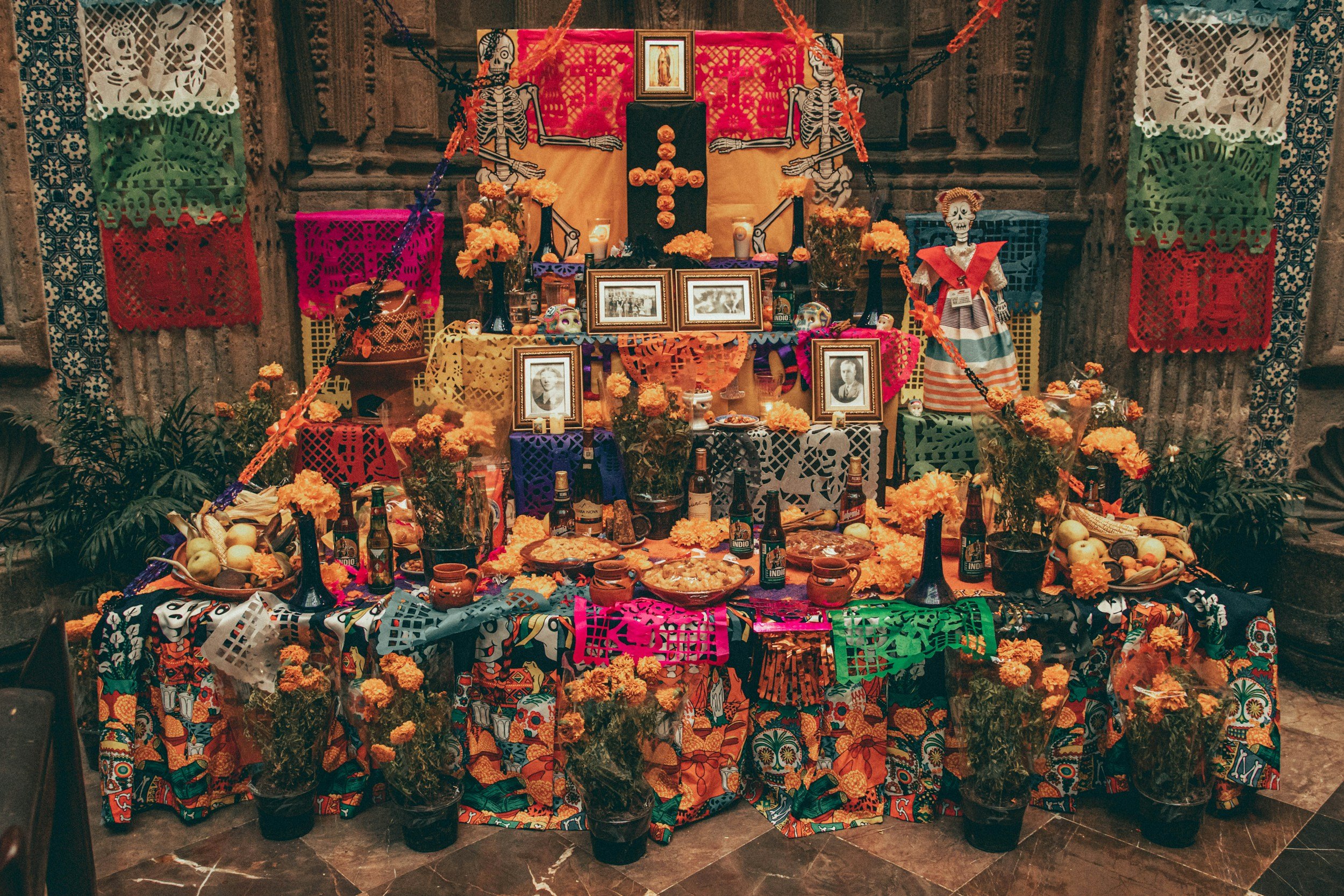 A richly decorated Day of the Dead ofrenda altar with family photographs, marigolds, food offerings and papel picado in Oaxaca, Mexico
