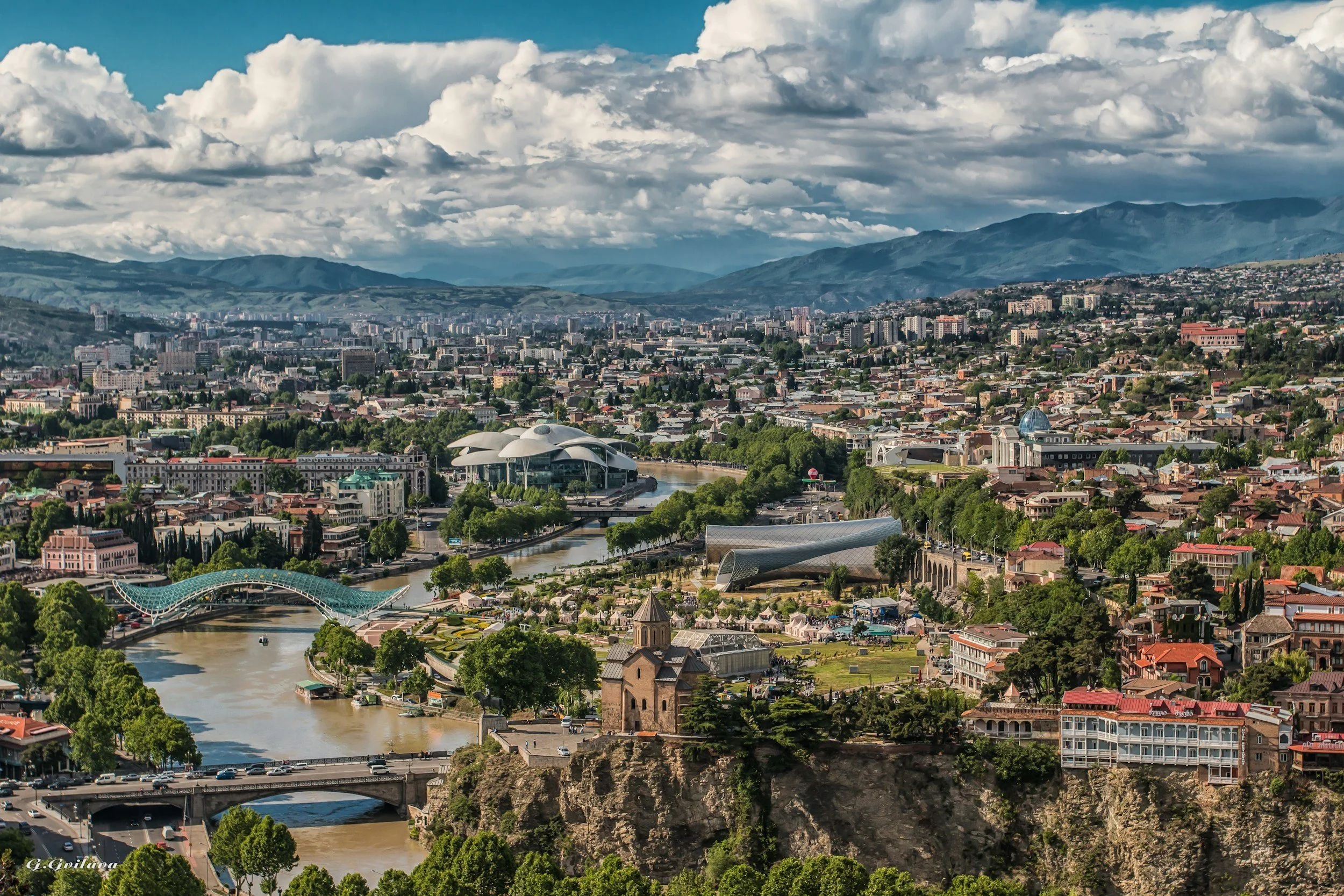 Aerial view of Tbilisi with the Bridge of Peace and the Mtkvari River winding through the historic centre of the Georgian capital