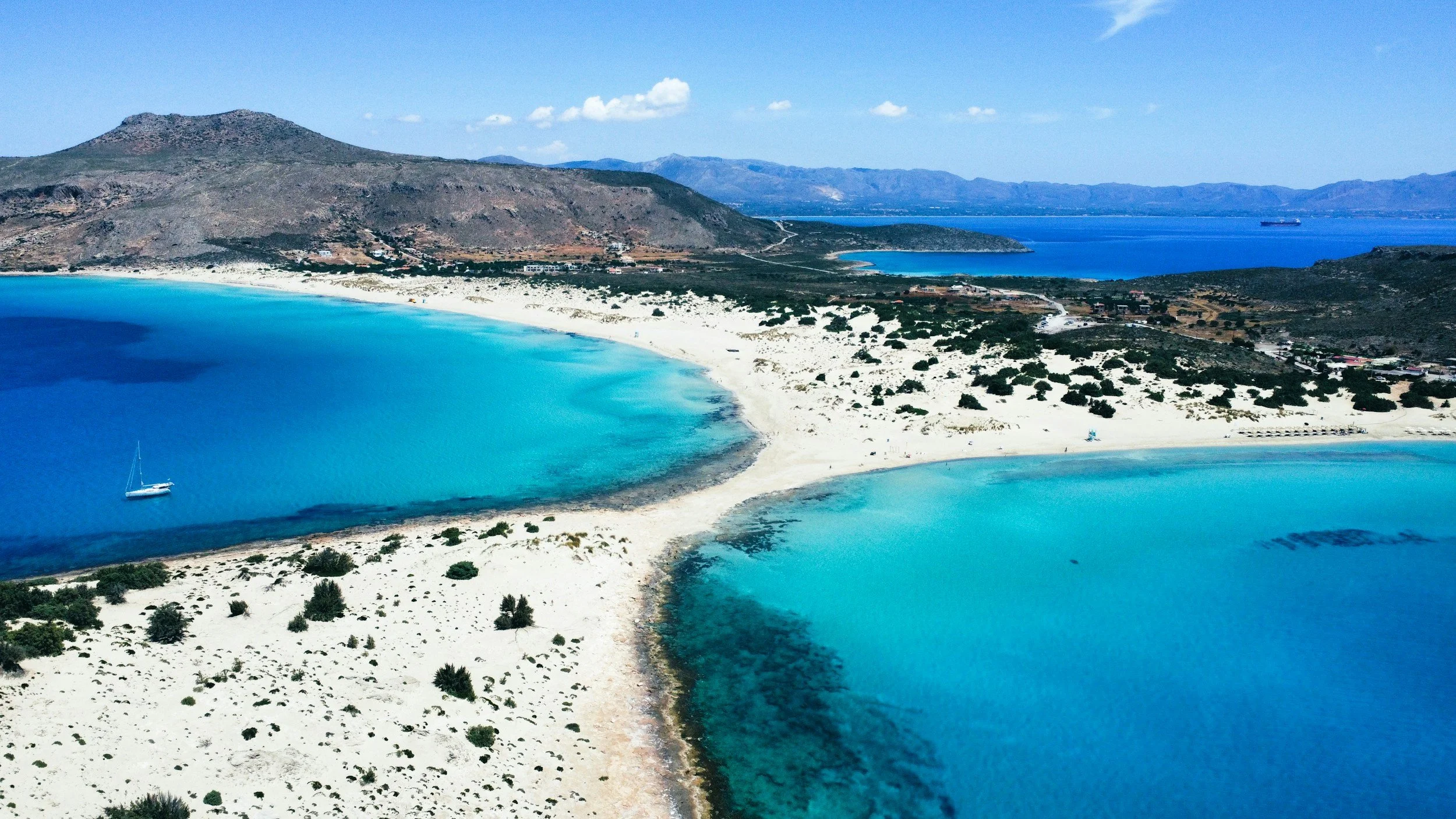 Aerial view of a remote white sand lagoon beach with shallow turquoise water on the Peloponnese peninsula, Greece, one of the country's least-visited coastlines