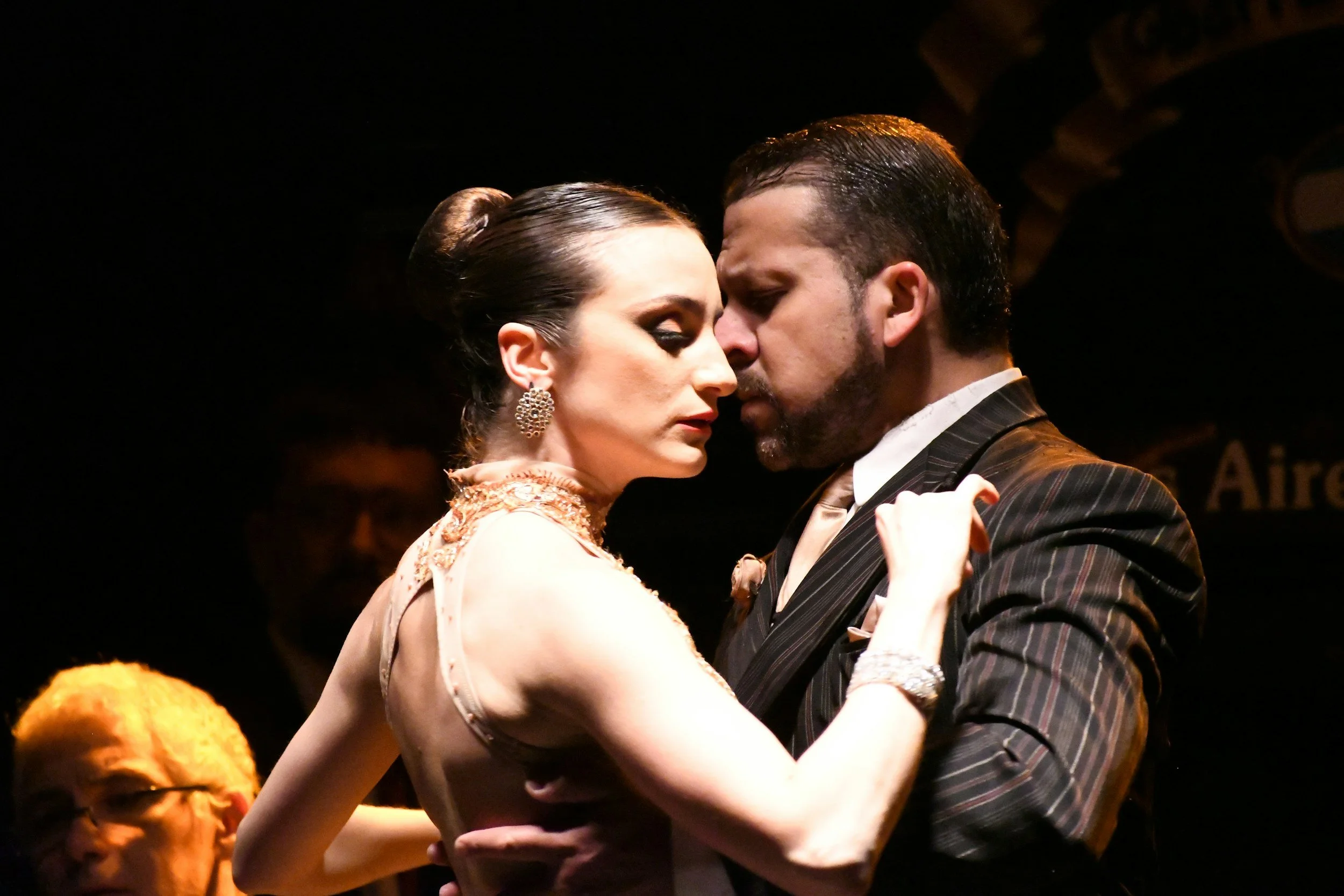 A couple of professional tango dancers in a close dramatic embrace on stage in Buenos Aires, the birthplace of tango, Argentina