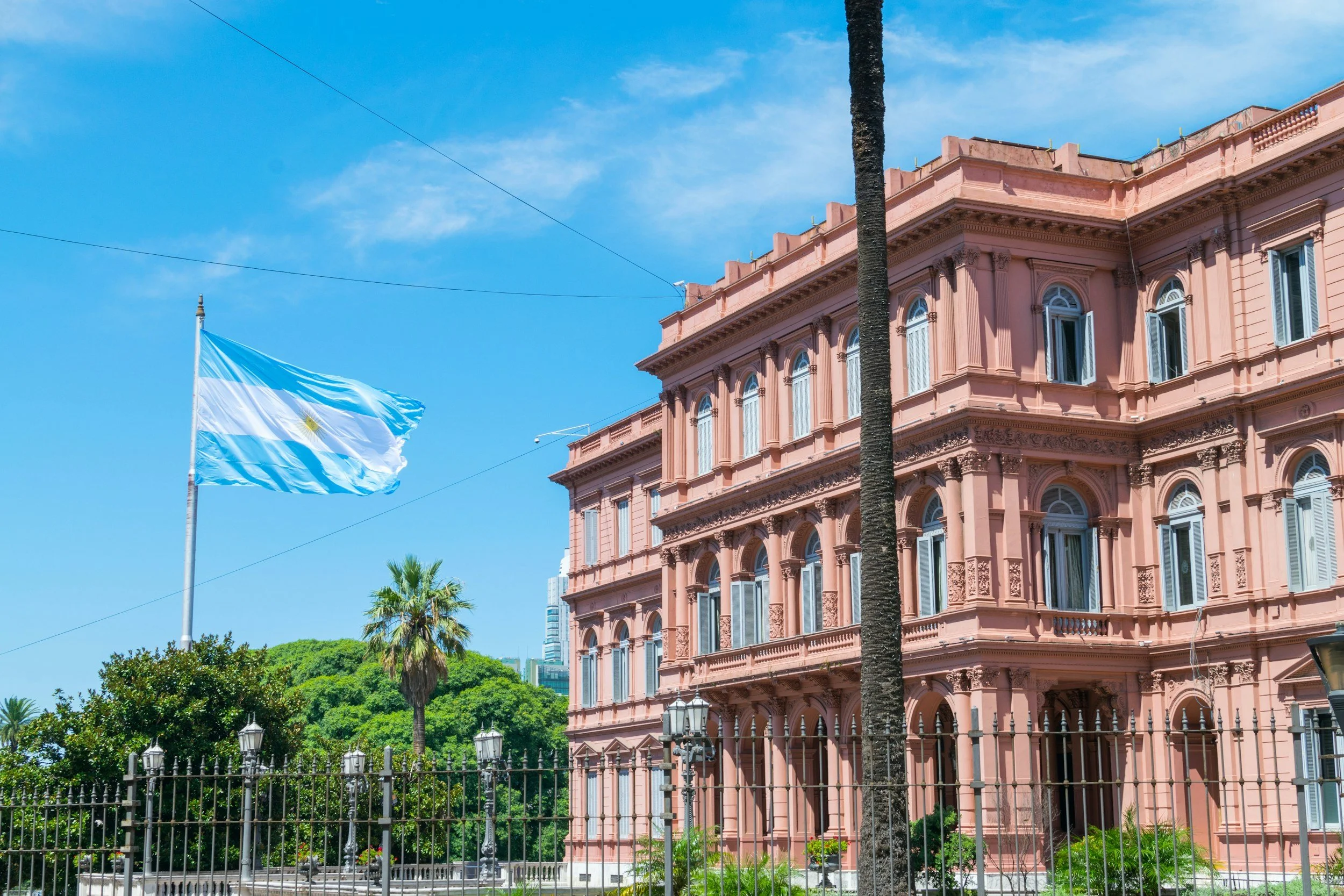 The pink neoclassical façade of the Casa Rosada presidential palace with the Argentine flag flying above in Buenos Aires, Argentina