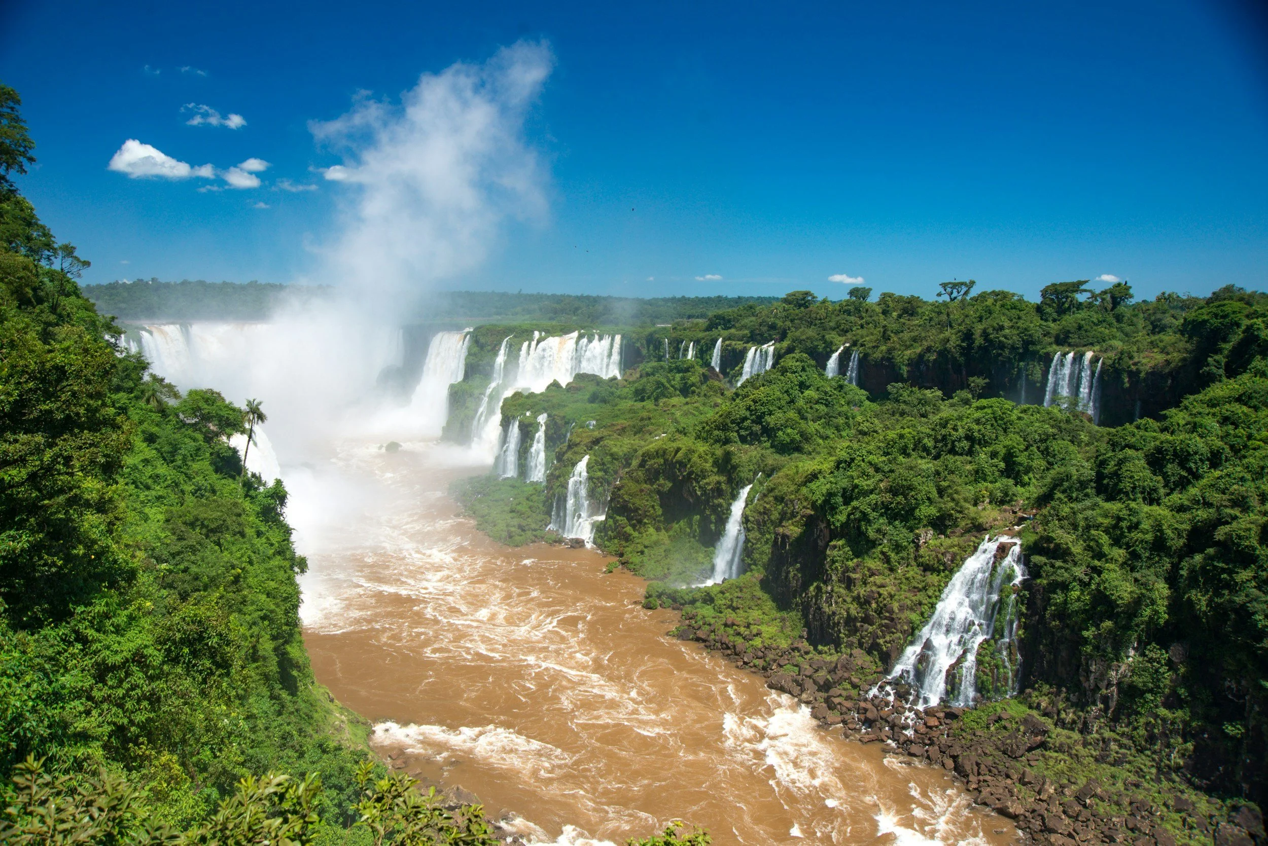 Aerial view of the Iguazú Falls with hundreds of cascades crashing into the river below and a plume of mist rising above the surrounding jungle, Argentina