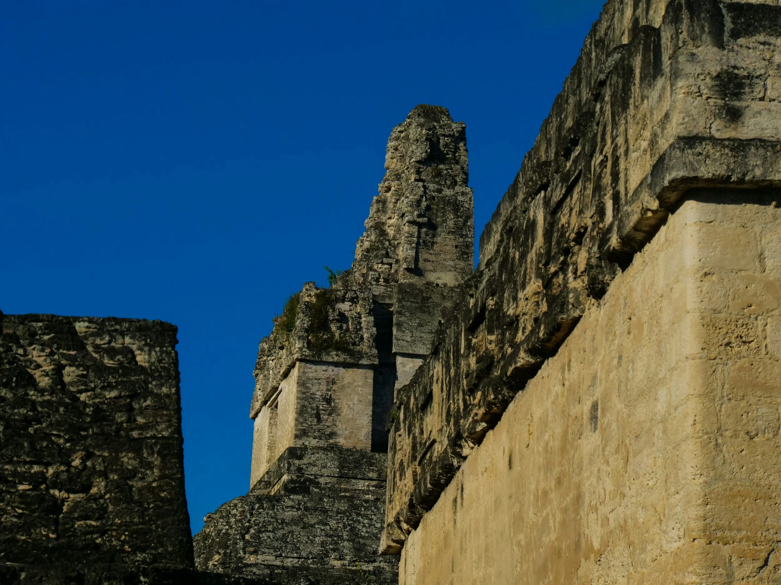 Stone stairways and carved temple walls of the Yaxhá Mayan ruins glowing in warm sunset light in the Petén jungle, Guatemala
