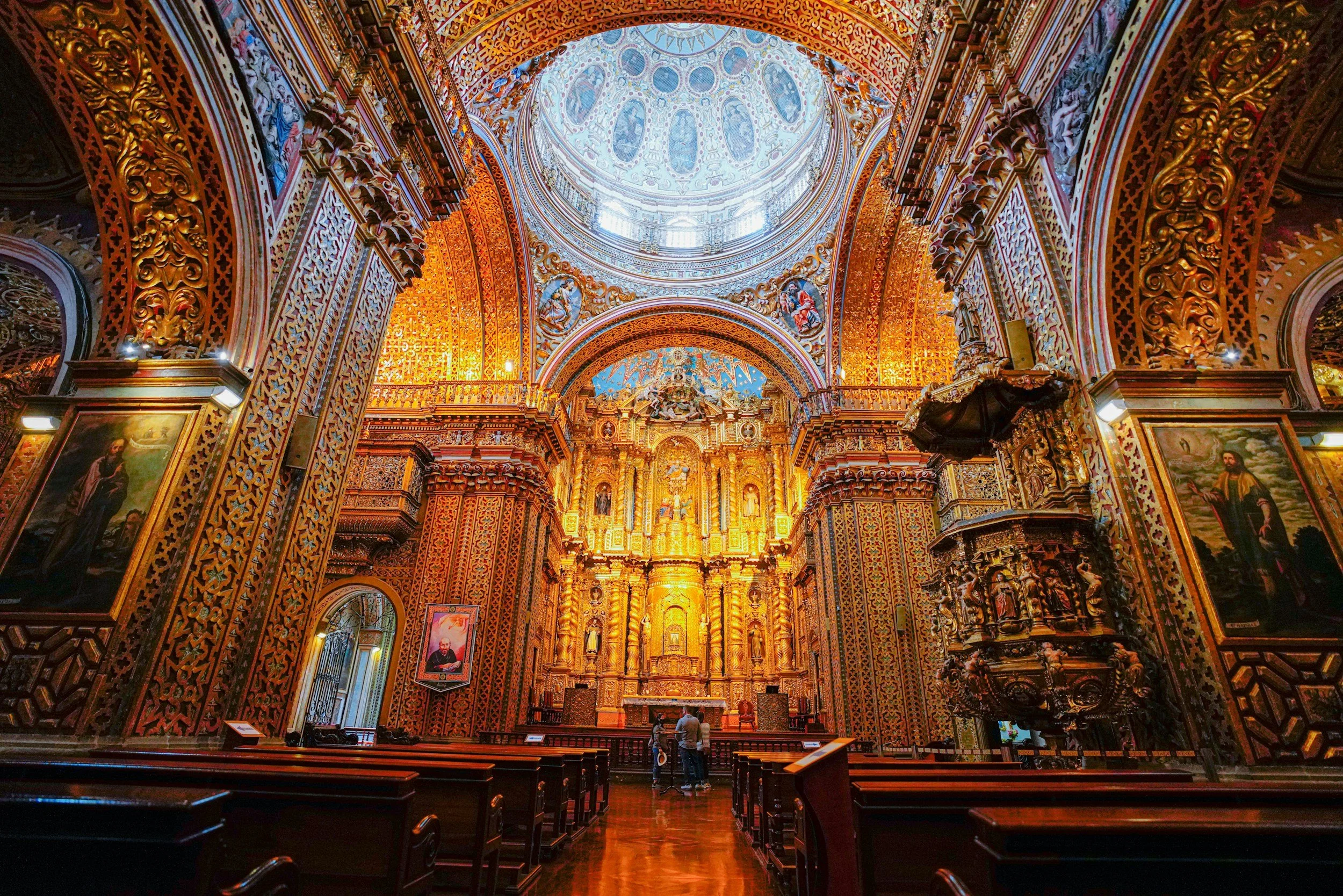 Breathtaking gilded baroque interior of La Compañía de Jesús church in Quito with ornate golden altars and a painted dome ceiling, Ecuador