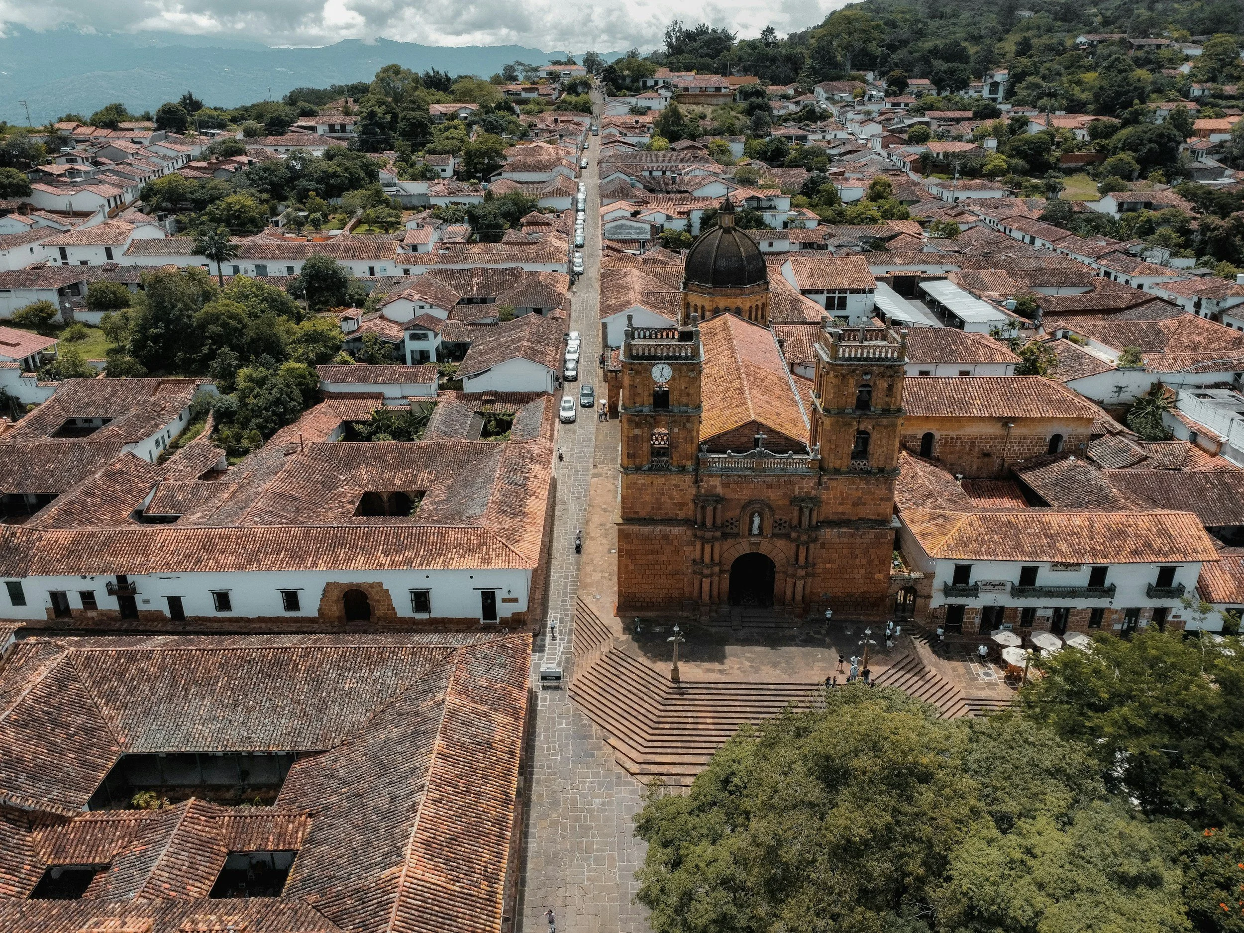 Aerial view of terracotta rooftops and a sandstone church tower in the colonial village of Barichara, Colombia
