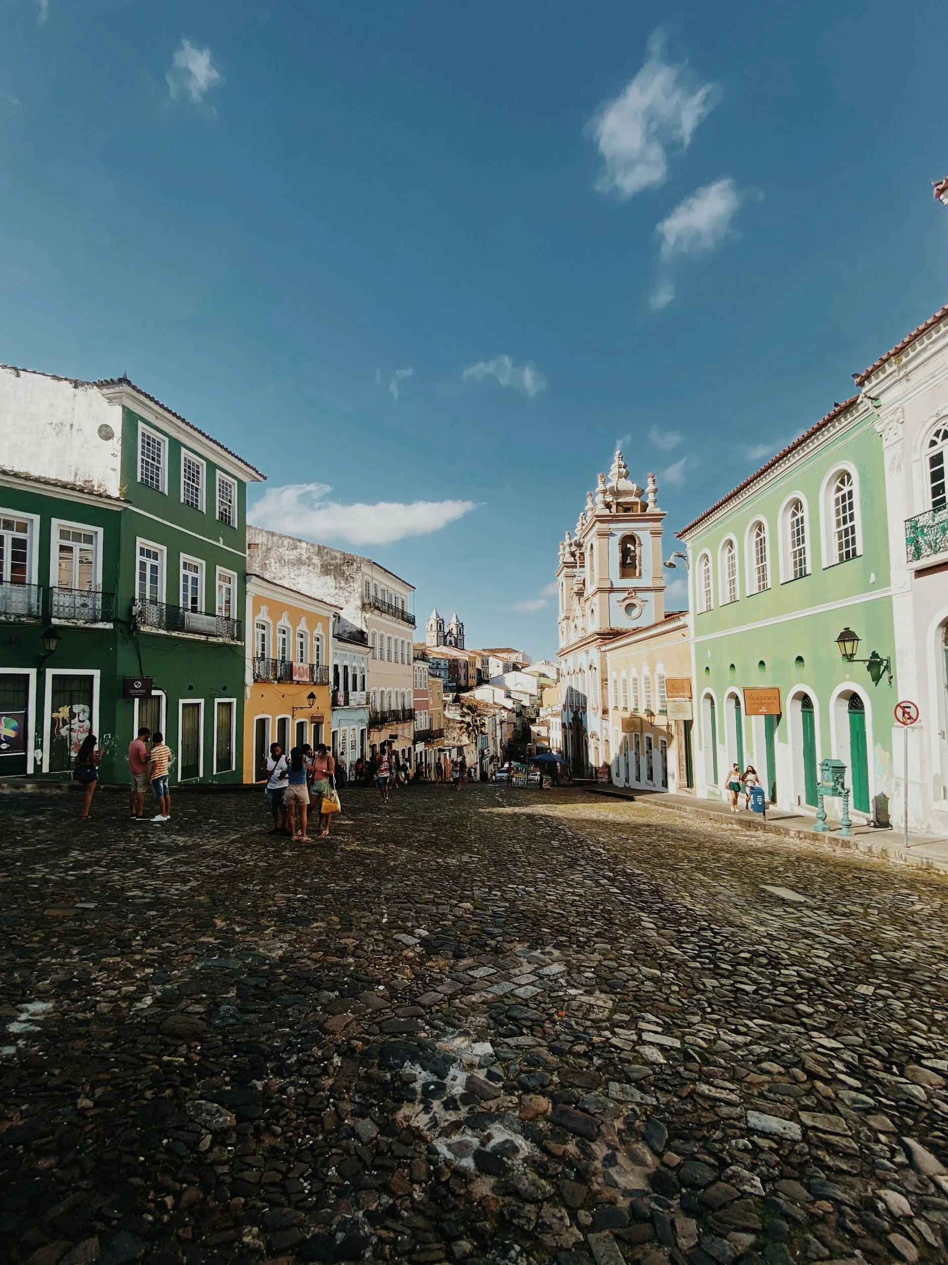 Travellers walking through the colourful colonial buildings and cobblestone streets of the Pelourinho district in Salvador de Bahia, Brazil