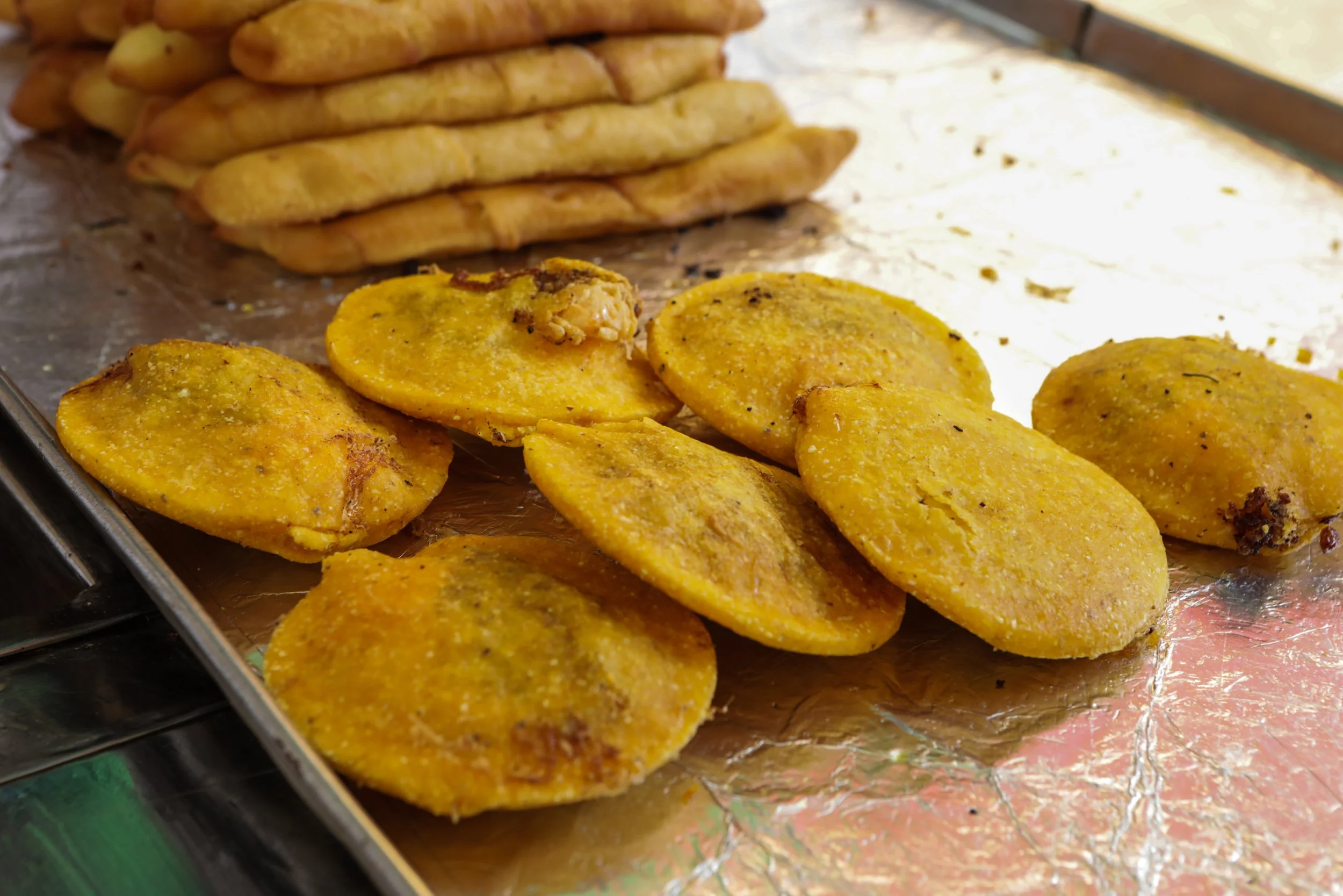 Close-up of golden fried Colombian empanadas and patacones freshly made during a private cooking class, Colombia