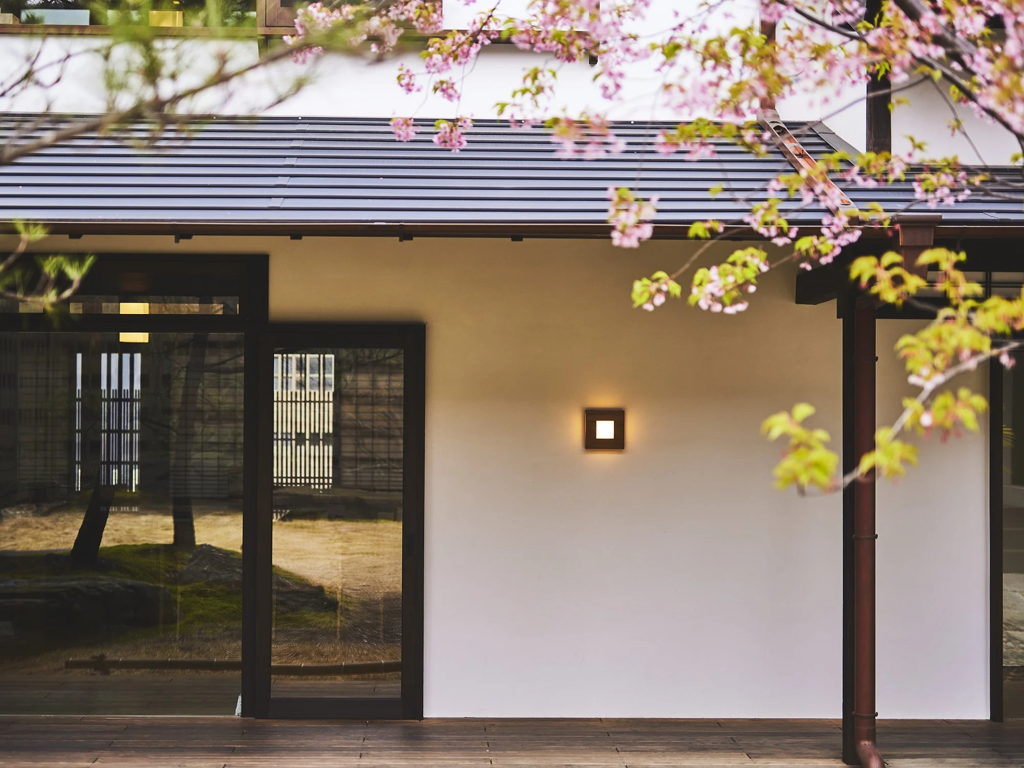The serene exterior courtyard of Azumi Setoda boutique hotel with cherry blossom trees on Ikuchijima island in the Seto Inland Sea, Japan