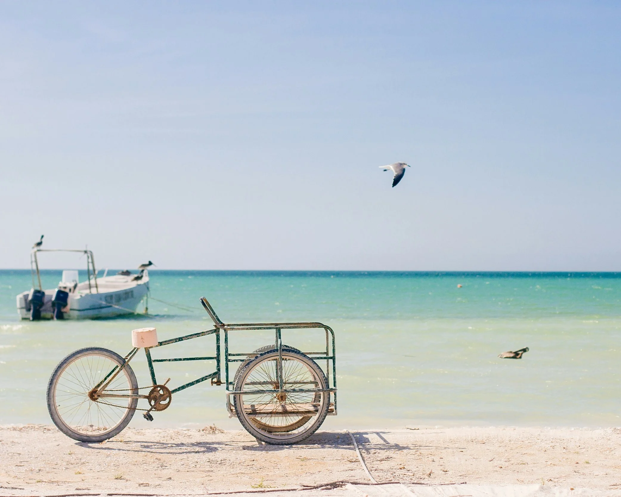 Tranquil turquoise waters and a fishing boat on a white sand beach on the Yucatán Peninsula, Mexico