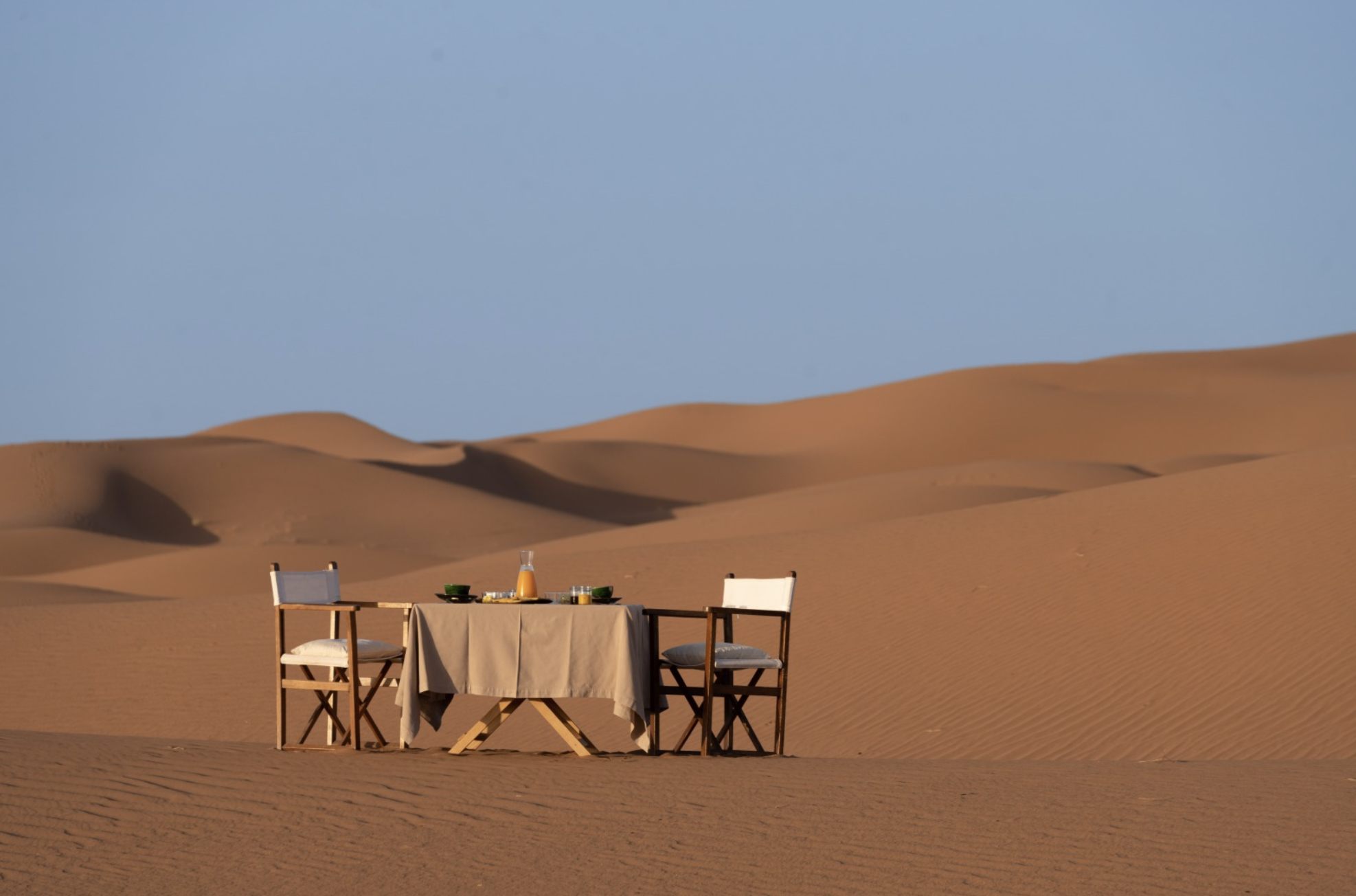 Camel caravan silhouetted against Erg Chebbi dunes at sunset, Sahara Desert, Morocco