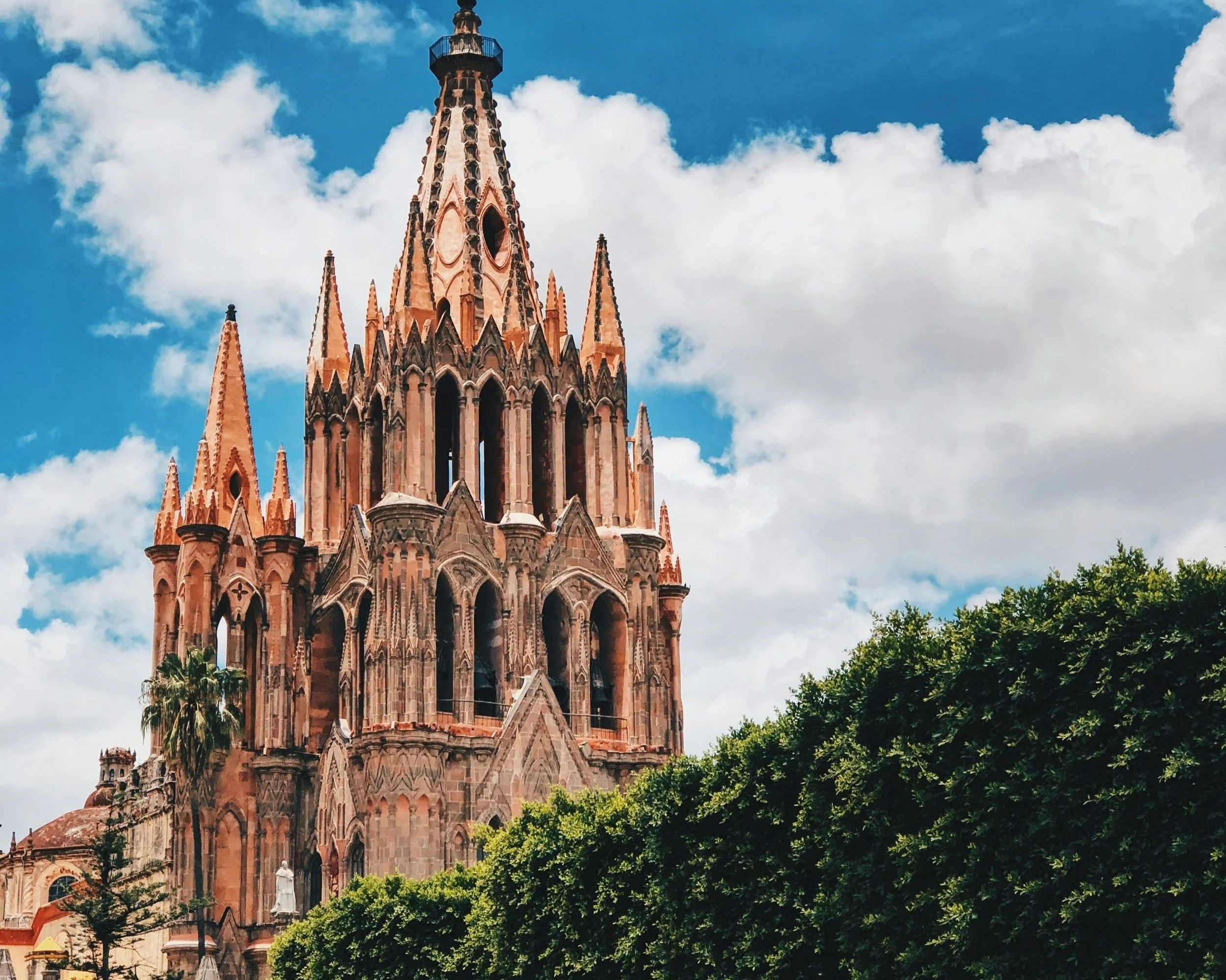 The neo-Gothic pink stone towers of La Parroquia de San Miguel Arcángel rising above San Miguel de Allende, Mexico