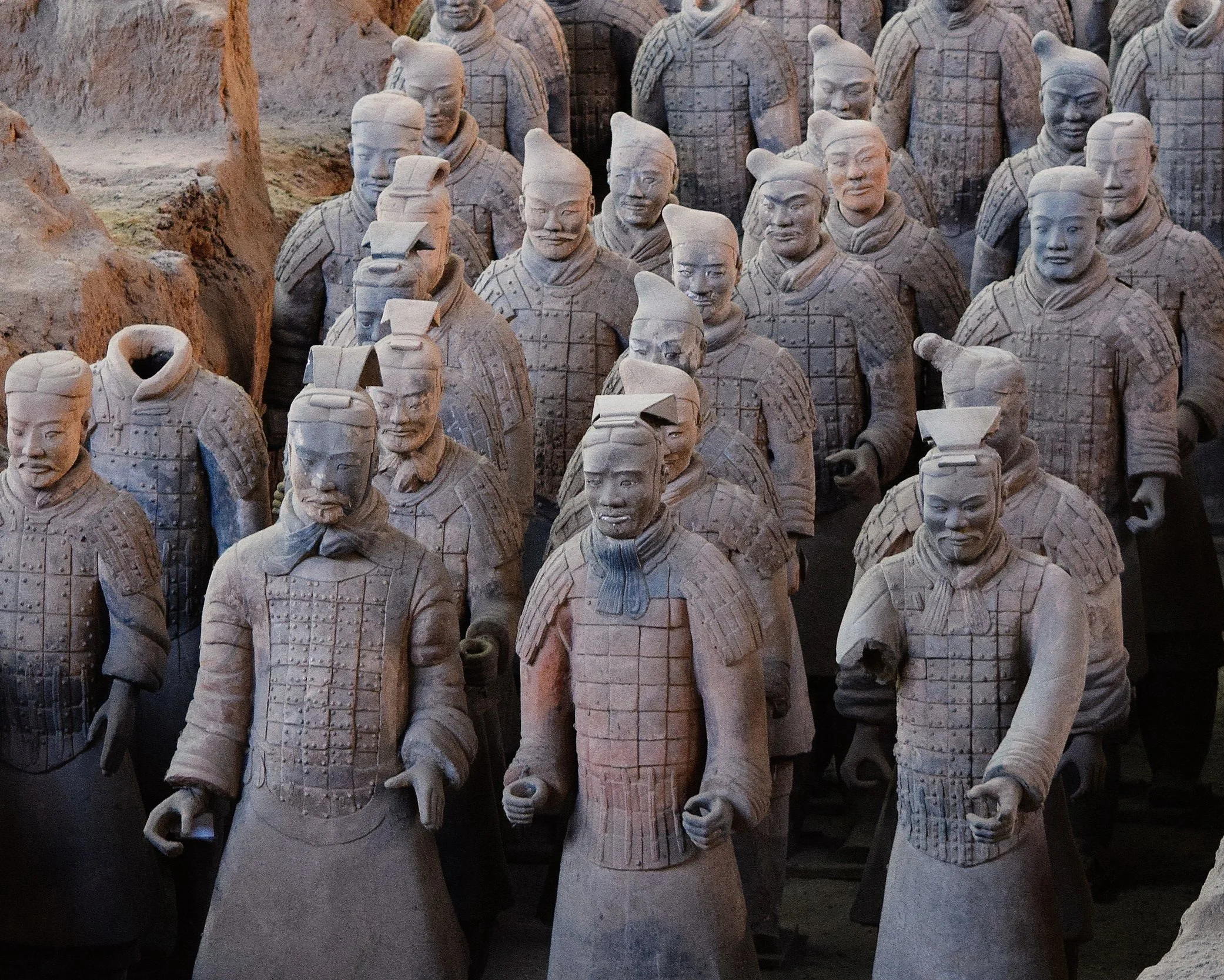 Close-up view of rows of terracotta warrior figures with individual facial features at the Mausoleum of Qin Shi Huang near Xi'an, China, showing the remarkable detail of their armour and expressions