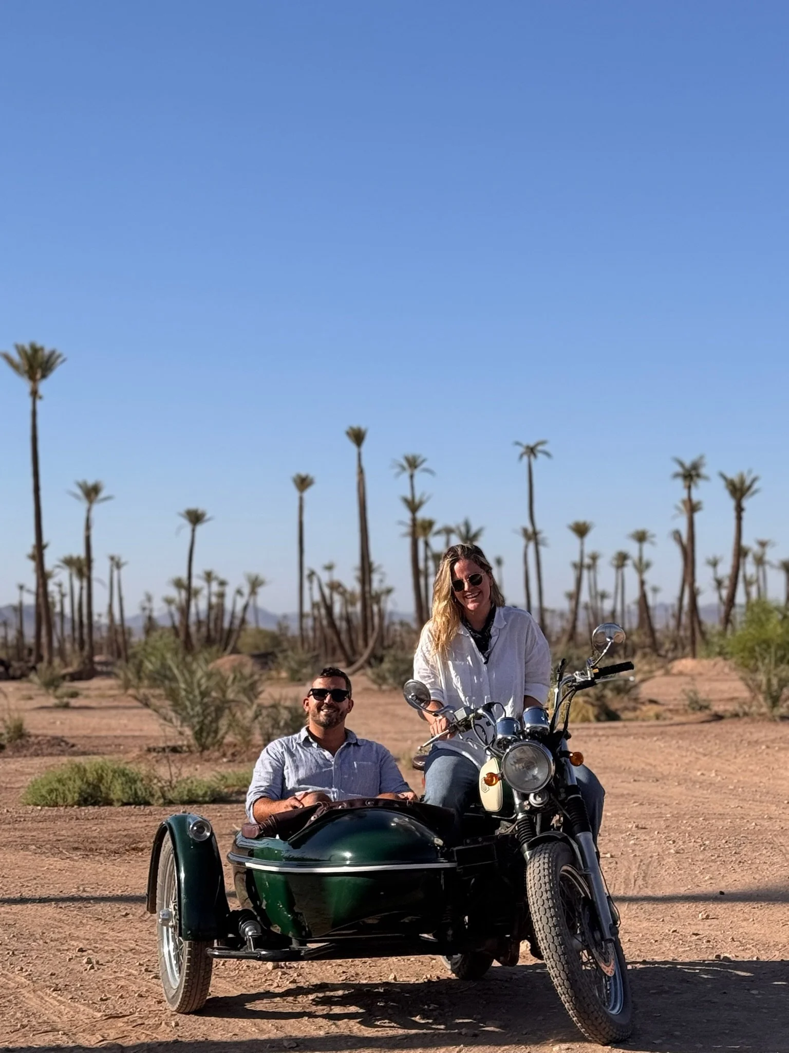 Couple on a vintage sidecar motorcycle tour through the Marrakech Palmeraie, Morocco