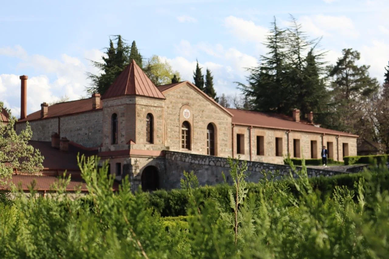 Stone winery building surrounded by lush greenery in the Kakheti wine region of Georgia, home to the world's oldest winemaking tradition using qvevri clay vessels