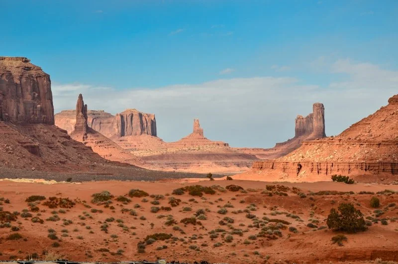 Vast red rock desert landscape with flat-topped mesa formations rising from dusty plains under a clear blue sky in the ancient terrain of Damaraland, Namibia