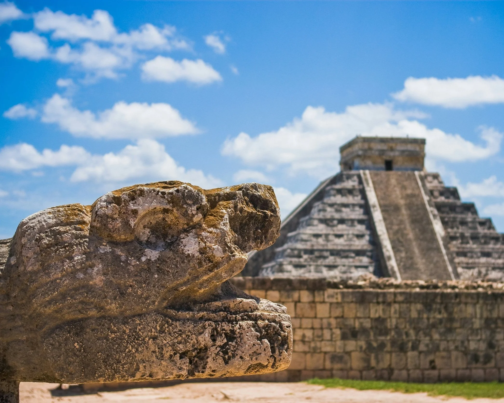 Stone serpent head sculpture at the base of El Castillo pyramid at Chichén Itzá on a private luxury tour of Mexico