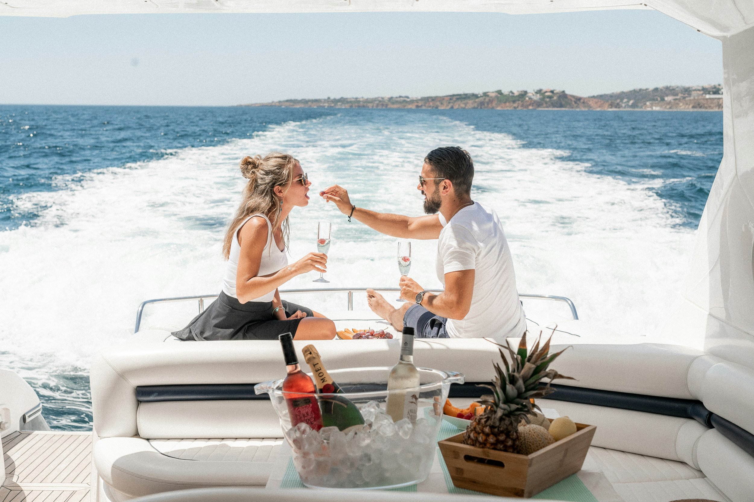 Couple relaxing with champagne on a private yacht in the Albanian Riviera at sunset
