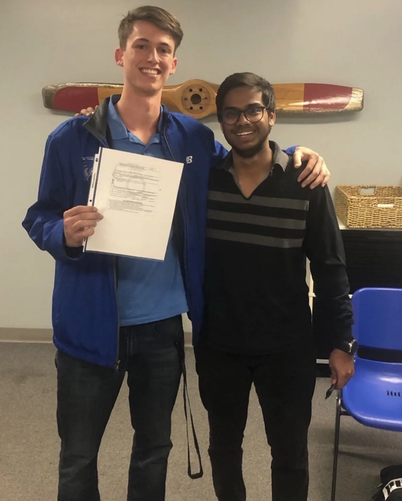 Garrett and Adnan next to each other at Treasure Coast Flight Training, holding up a certificate. 