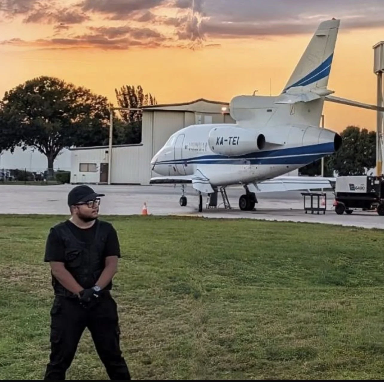 Rahul in front of a Falcon jet with a sunset in the background. 