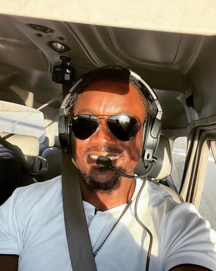 Francis in a Cessna 172 with his headset and sunglasses on smiling.