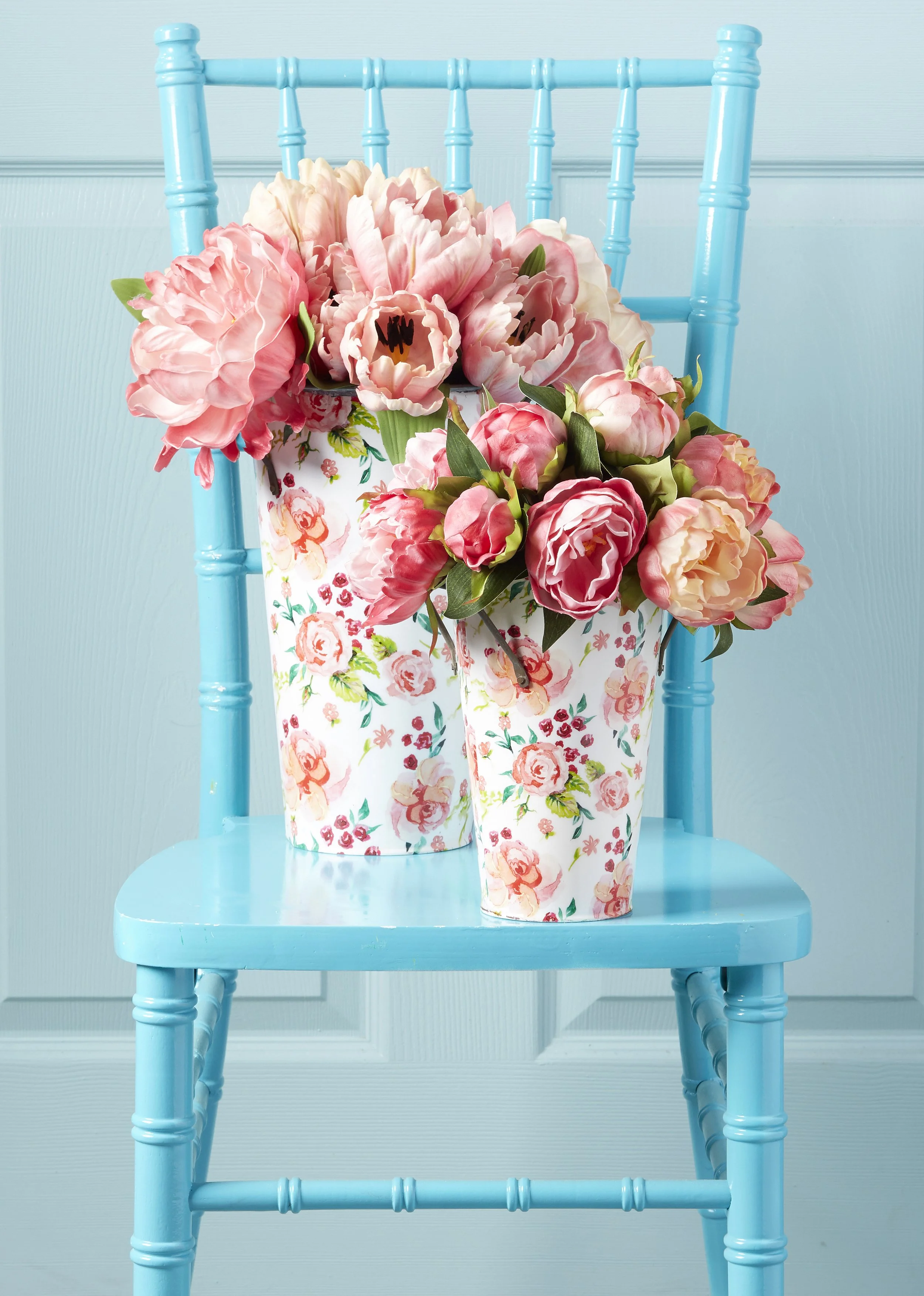 fresh cut pink roses and peonies on a bright blue chair