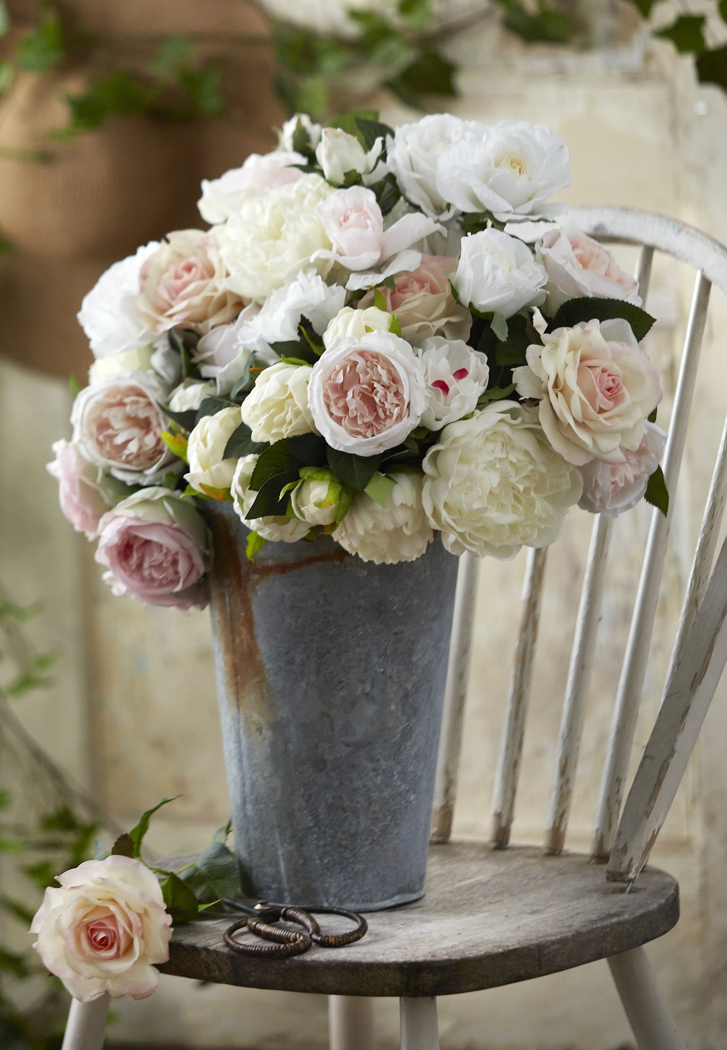 roses in a metal bucket on a chair, fresh cut floral