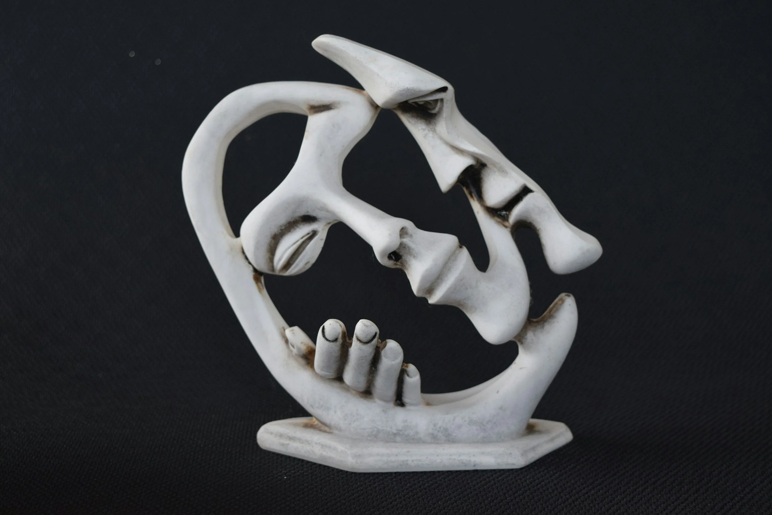 Sculpture of man embracing the face of a hollow woman