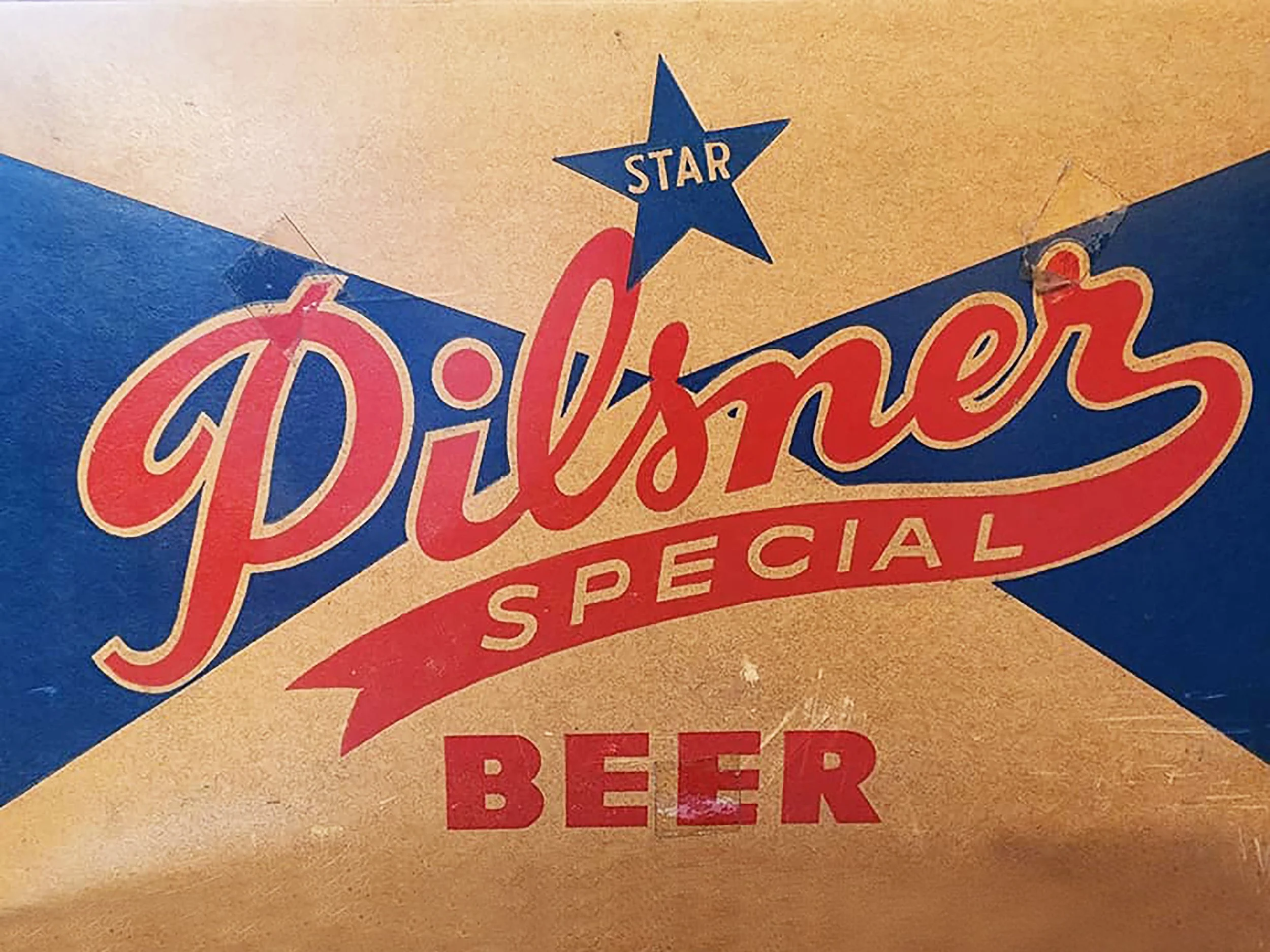 Close-up of a vintage-style promotional sign for Pilsner Special Beer, featuring a blue star.