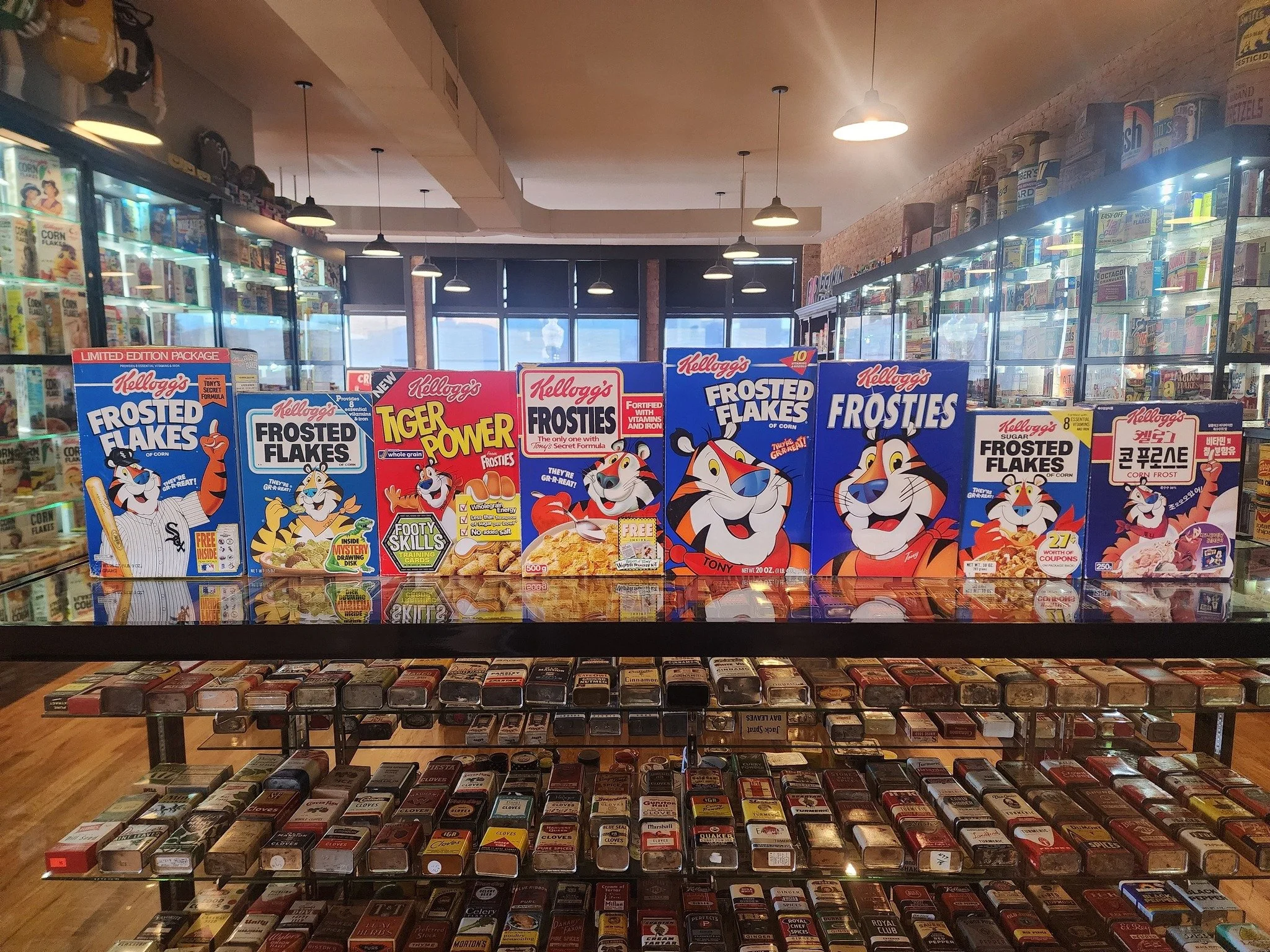 View the CBM featuring Kellogg's Frosted Flakes cereal boxes on display, with other cereal brands and products visible on shelves and in the refrigerated section.
